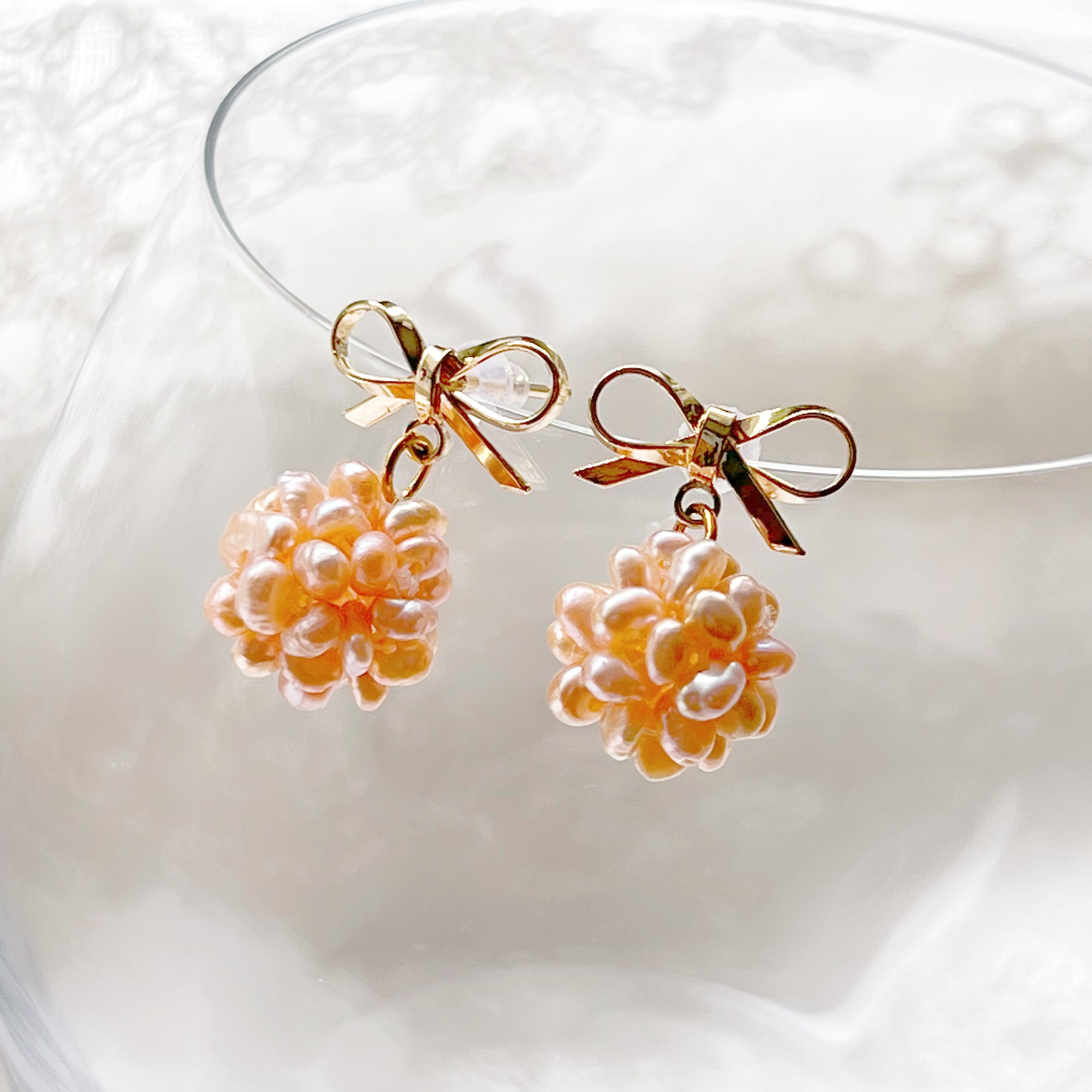 A pair of elegant pink pearl cluster drop earrings featuring globe-shaped freshwater pearls and gold-plated studs, beautifully arranged.