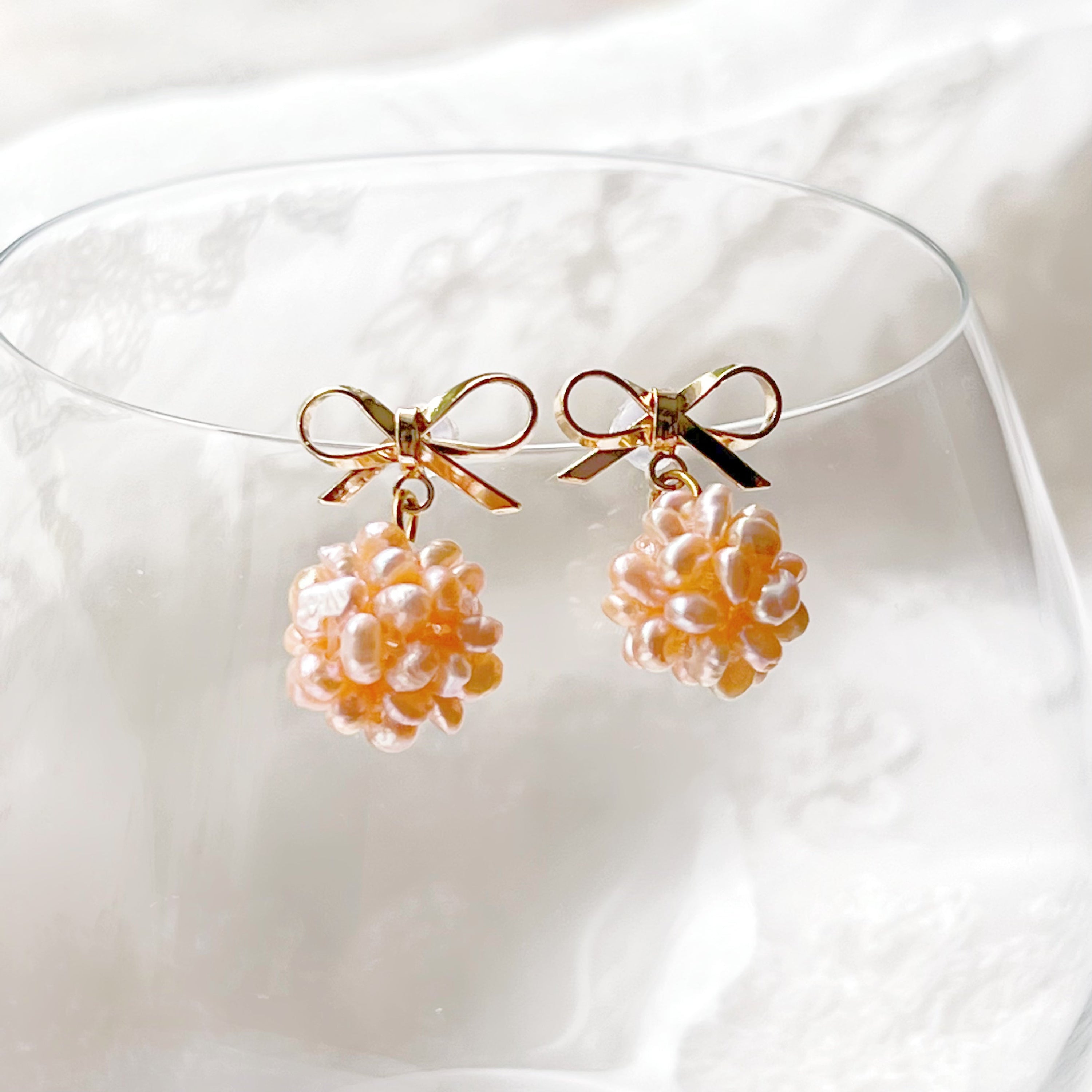 A pair of elegant pink pearl cluster drop earrings featuring globe-shaped freshwater pearls and gold-plated studs, beautifully arranged.