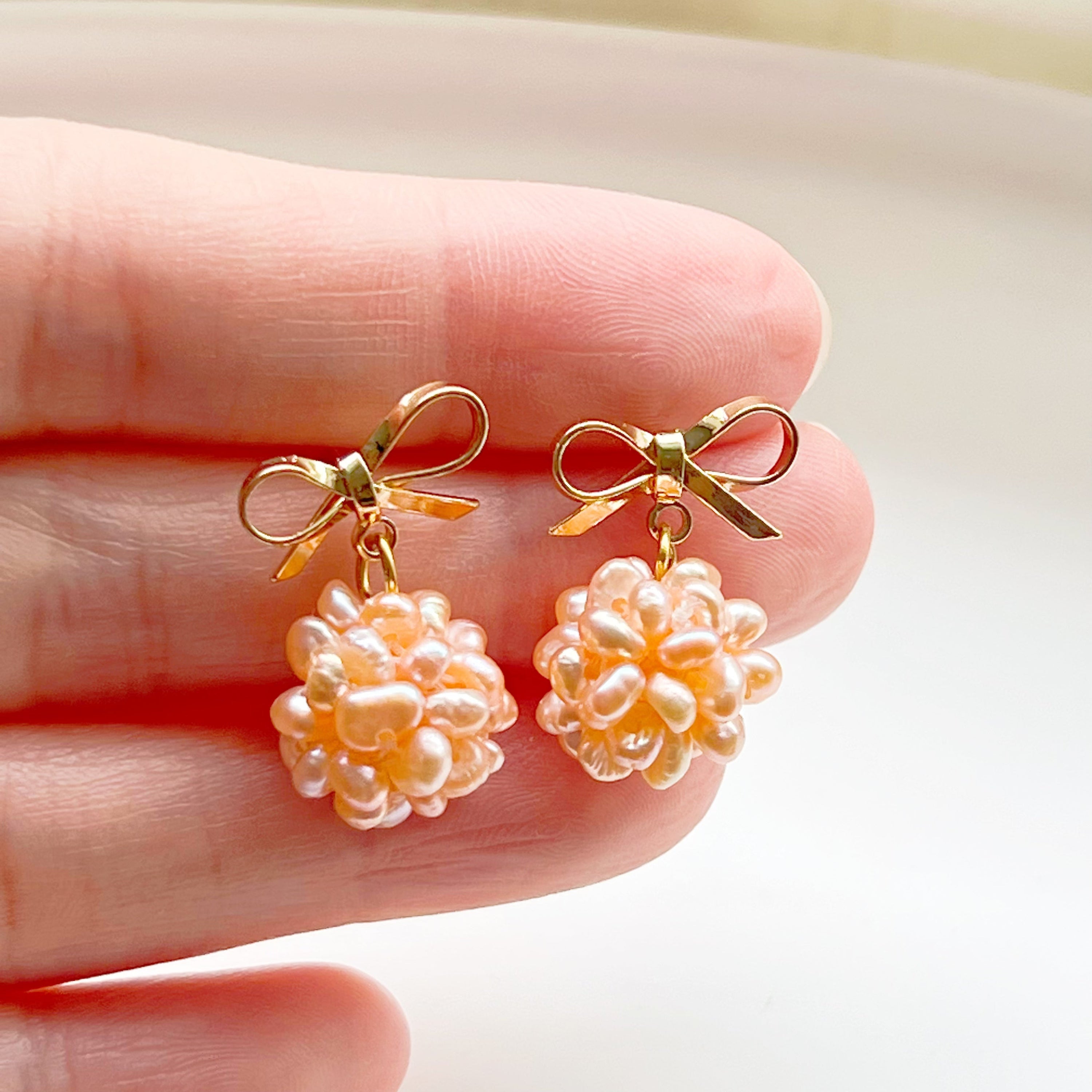 A pair of elegant pink pearl cluster drop earrings featuring globe-shaped freshwater pearls and gold-plated studs, beautifully arranged.