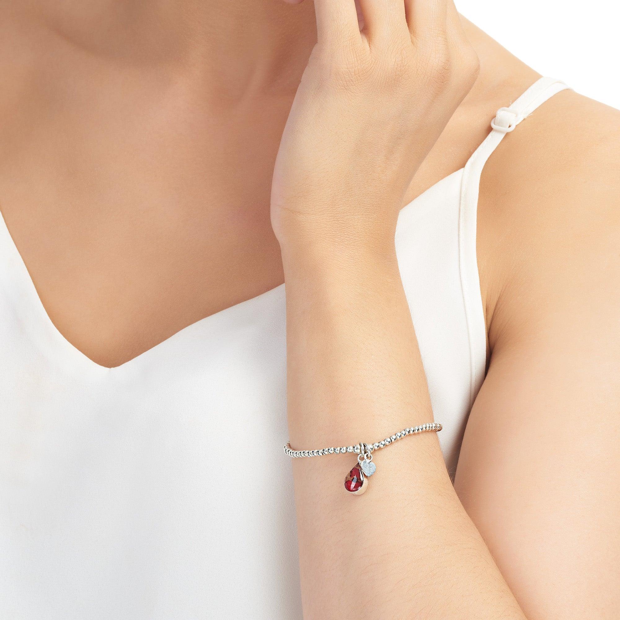 Poppy bracelet by Shrieking Violet featuring sterling silver beads and a real flower charm, elegantly displayed in a gift box.