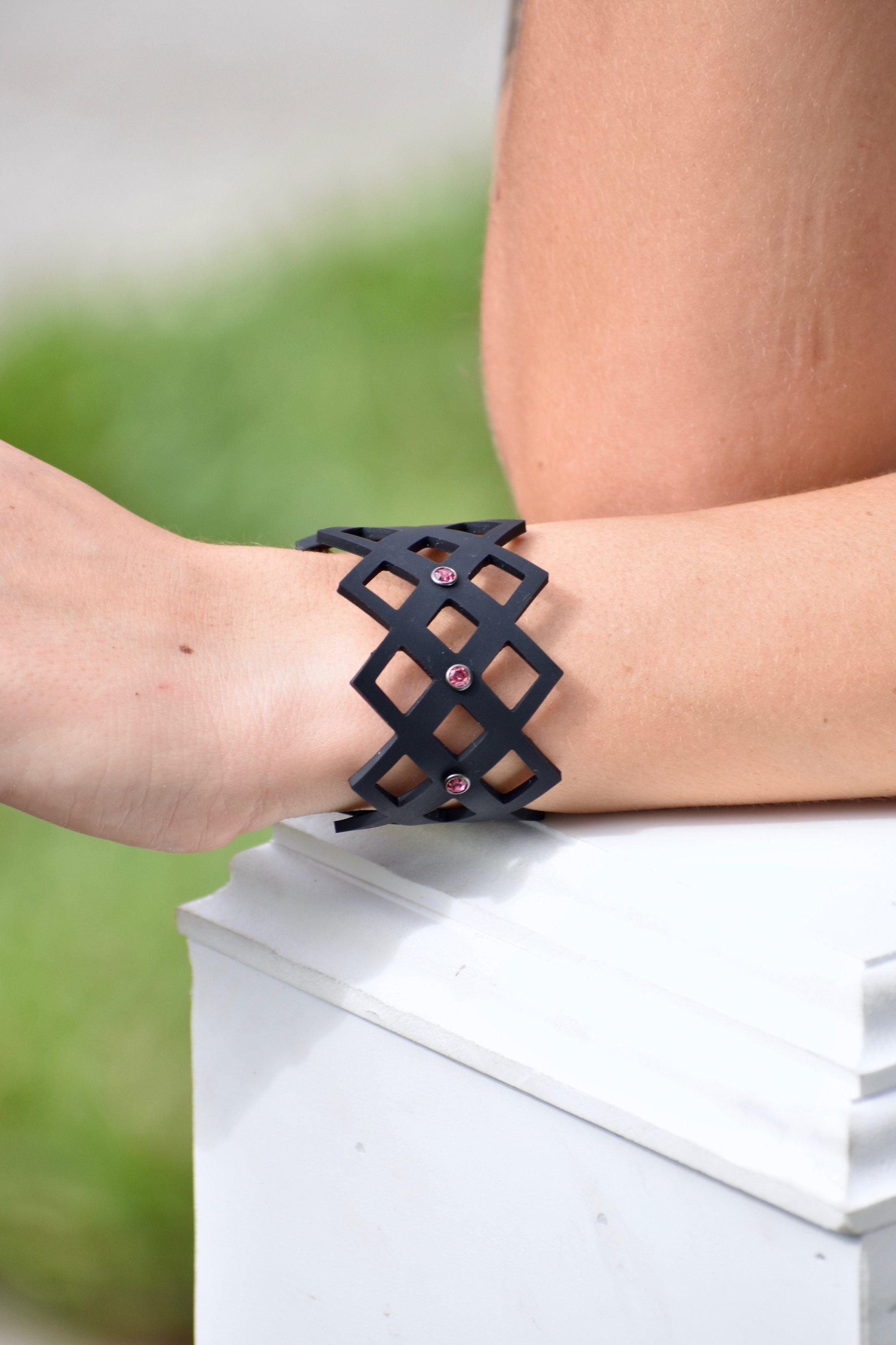 A stylish Pretty Bracelet displayed elegantly in a velvet pouch, showcasing its unique design and vibrant colors.