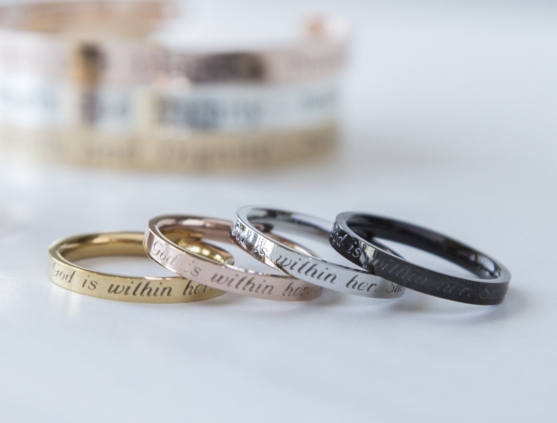 Psalm 46:5 Ring in gold, rose gold, and black plating, engraved with 'God is within her; she will not fail', showcasing its elegant design.