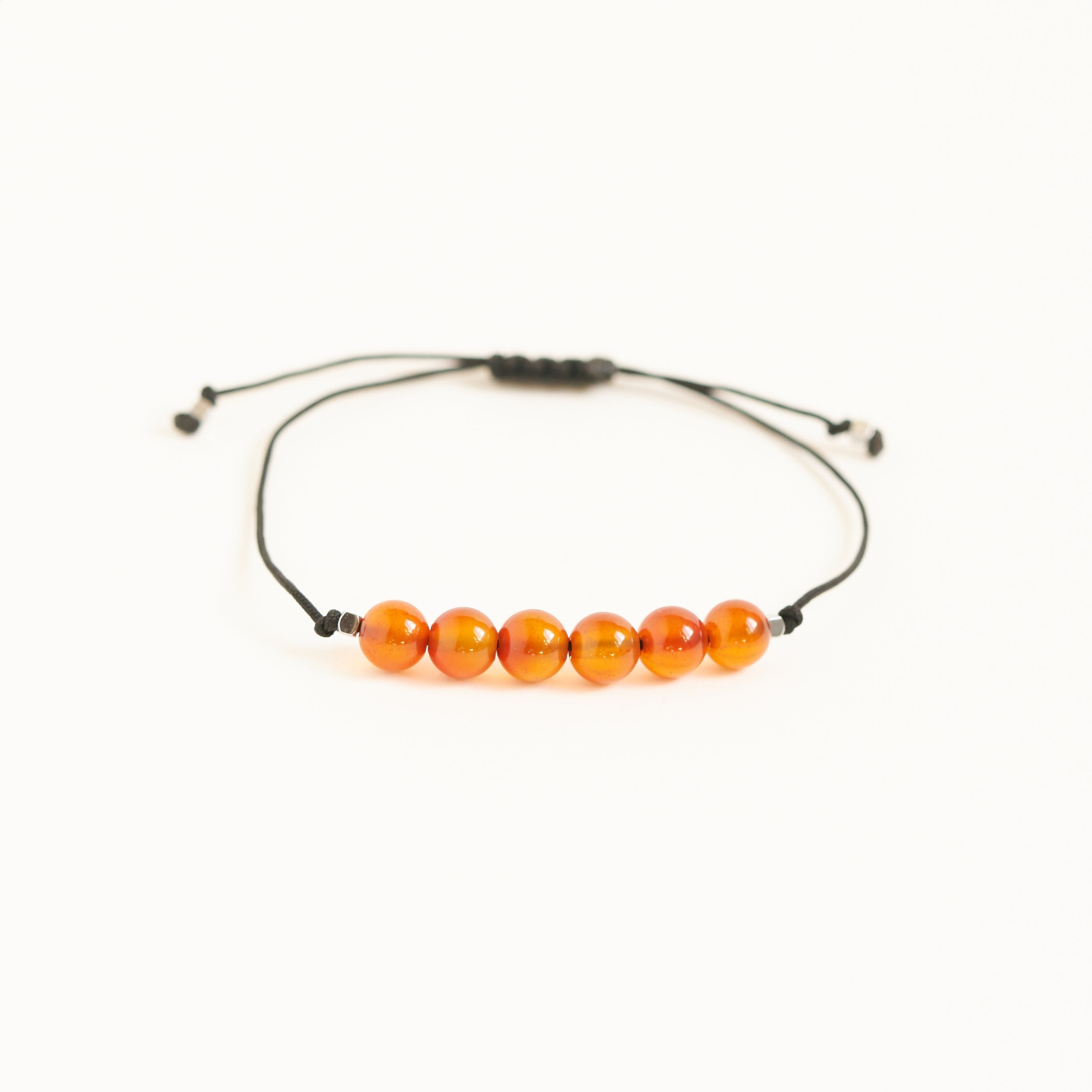 Pulsera de hilo negro con piedras de cornalina roja, ajustable y hecha a mano, ideal como regalo de cumpleaños para el mes de Julio.