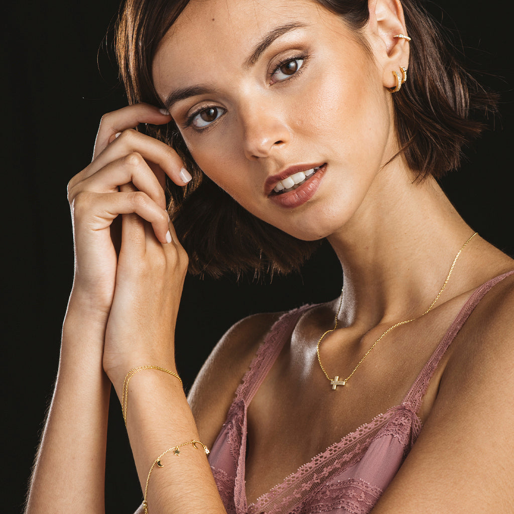 Pulsera de plata bañada en oro con colgantes de lunas y estrellas, adornada con circonitas blancas brillantes.