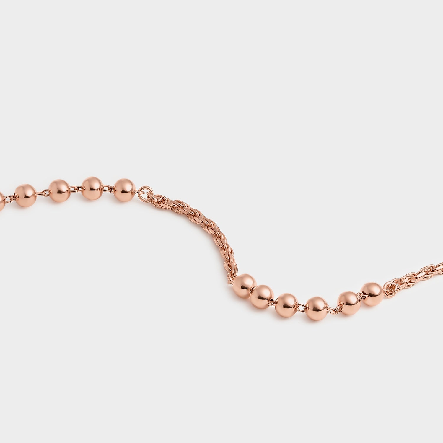 Pulsera de oro rosa con cadena tipo soga y bolitas, elegante y moderna, ideal para cualquier ocasión.
