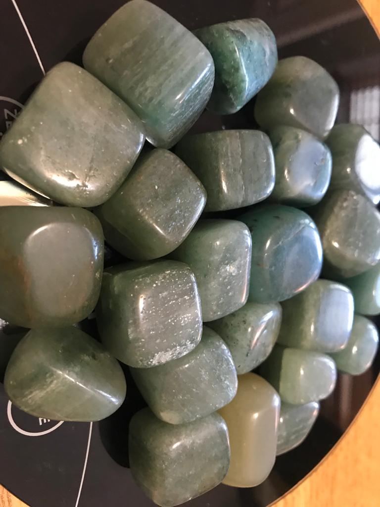 A collection of polished Rainbow Moonstone Tumbled Stones showcasing their iridescent colors and smooth surfaces.