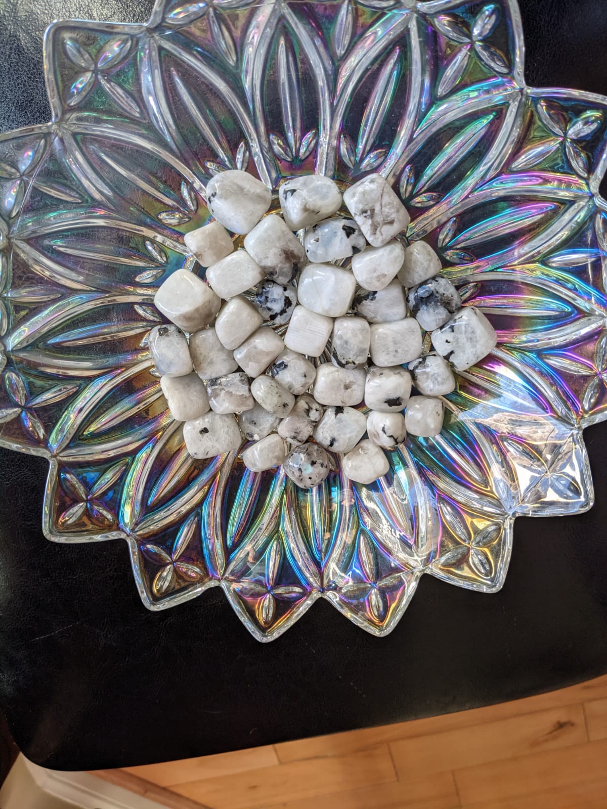 A collection of polished Rainbow Moonstone Tumbled Stones showcasing their iridescent colors and smooth surfaces.