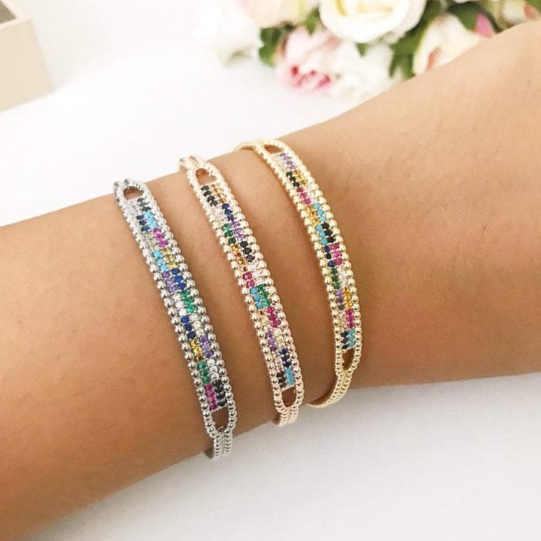 Rainbow Zircon Bangle Bracelet featuring turquoise beads and a movable evil eye charm in rose gold and silver finishes.