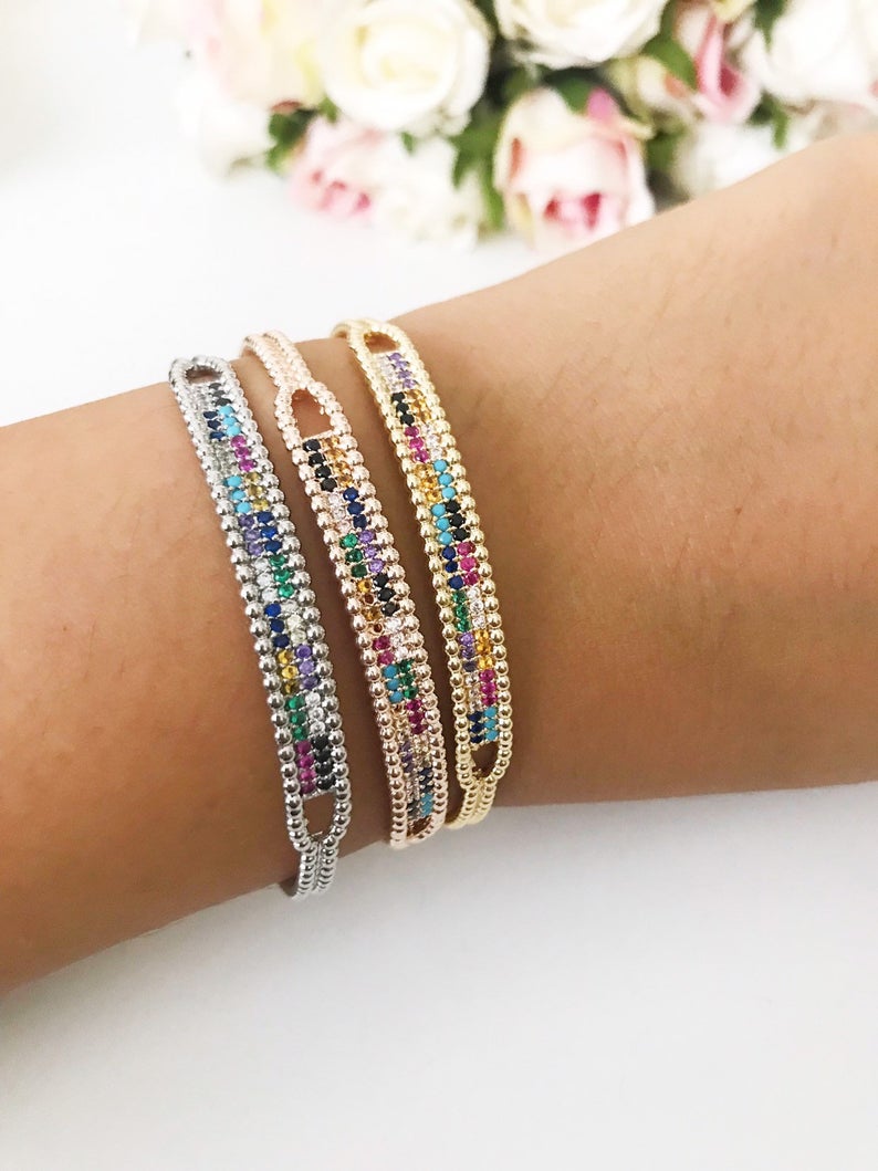 Rainbow Zircon Bangle Bracelet featuring turquoise beads and a movable evil eye charm in rose gold and silver finishes.