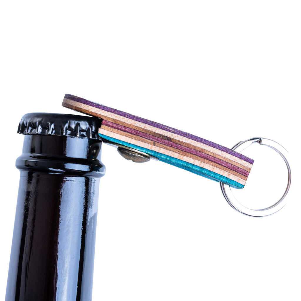 A colorful Recycled Skateboard Bottle Opener Keyring showcasing unique patterns and textures from upcycled skateboards.
