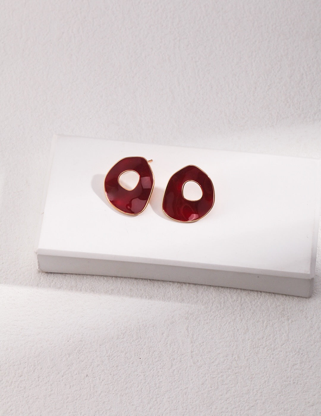 A pair of handmade red drip glaze irregular oval earrings made from sterling silver and gold vermeil, showcasing a unique artistic design.