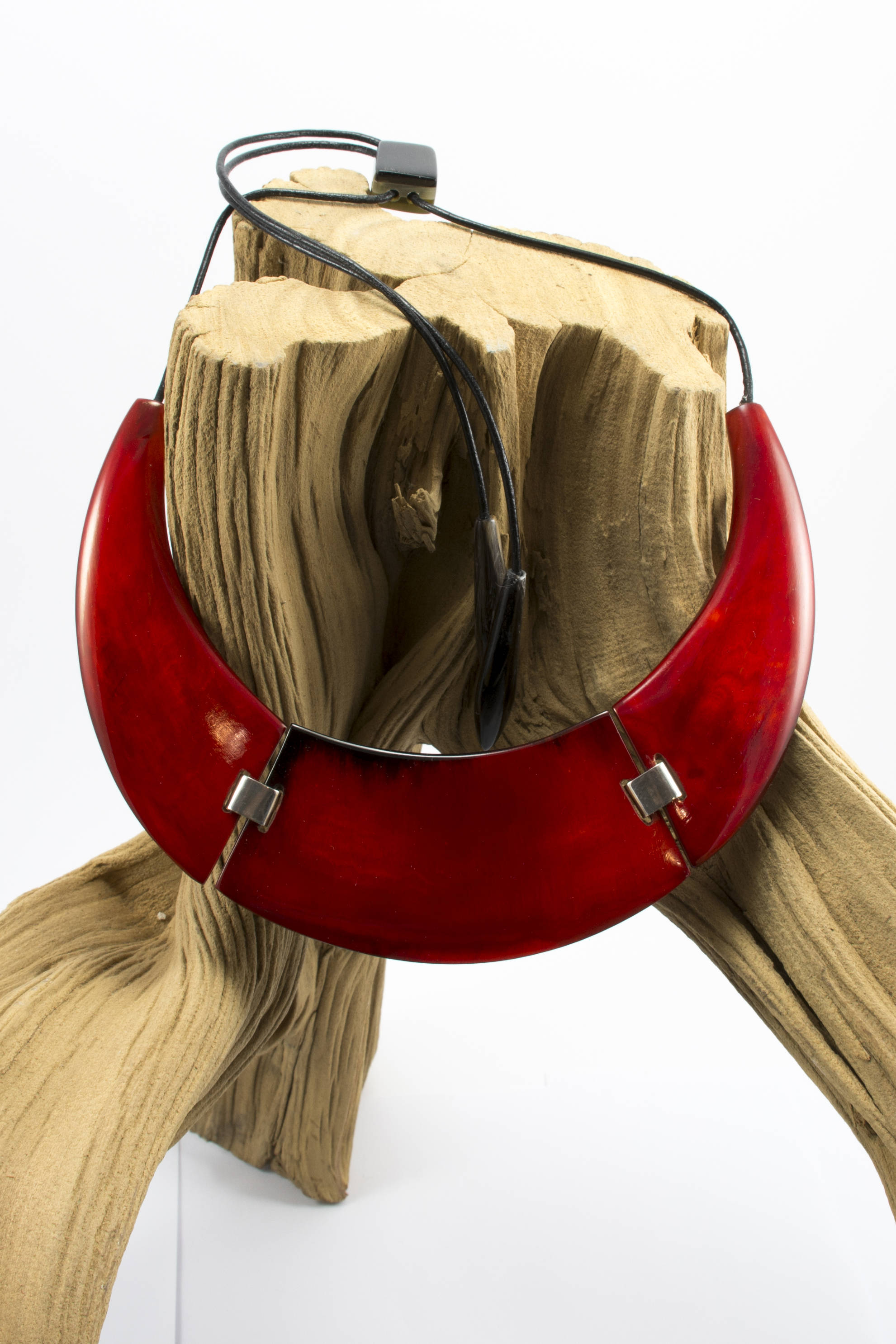 A stunning red gothic necklace featuring a unique crescent shape, handcrafted from horn with an adjustable length and horn clasp.