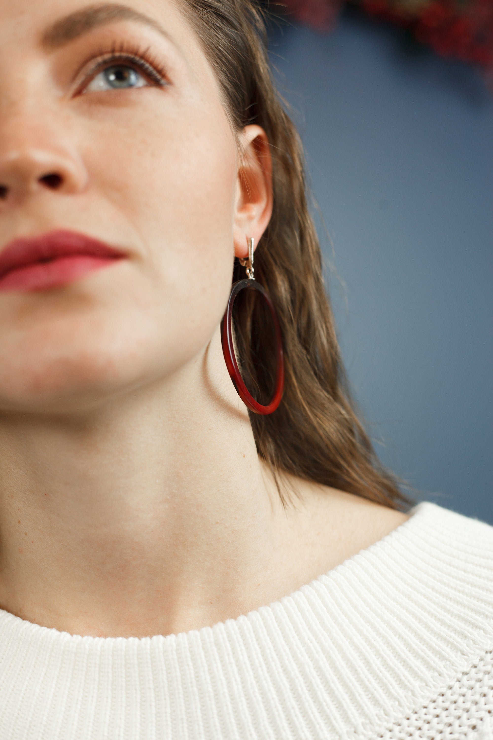 A pair of handmade red hoop earrings made from cow horn with 925 sterling silver ear locks, showcasing a bold and elegant design.