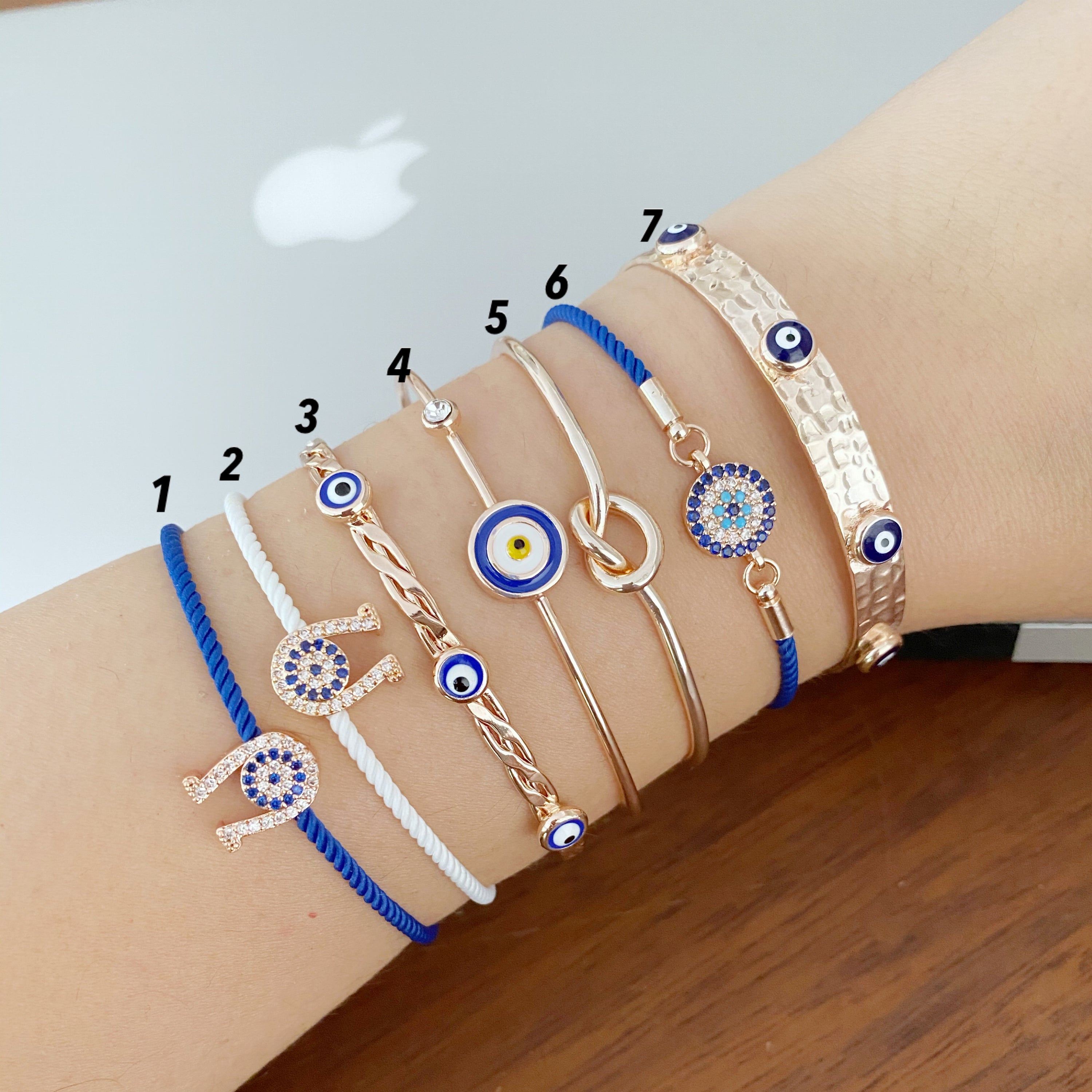 A beautiful Rose Gold Evil Eye Bracelet Set featuring various styles including bangles and cuffs, showcasing intricate designs and a protective evil eye symbol.