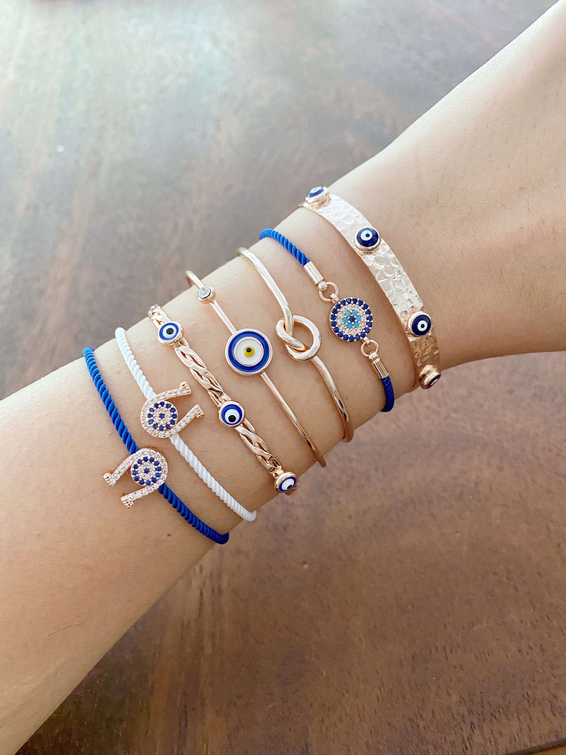 A beautiful Rose Gold Evil Eye Bracelet Set featuring various styles including bangles and cuffs, showcasing intricate designs and a protective evil eye symbol.