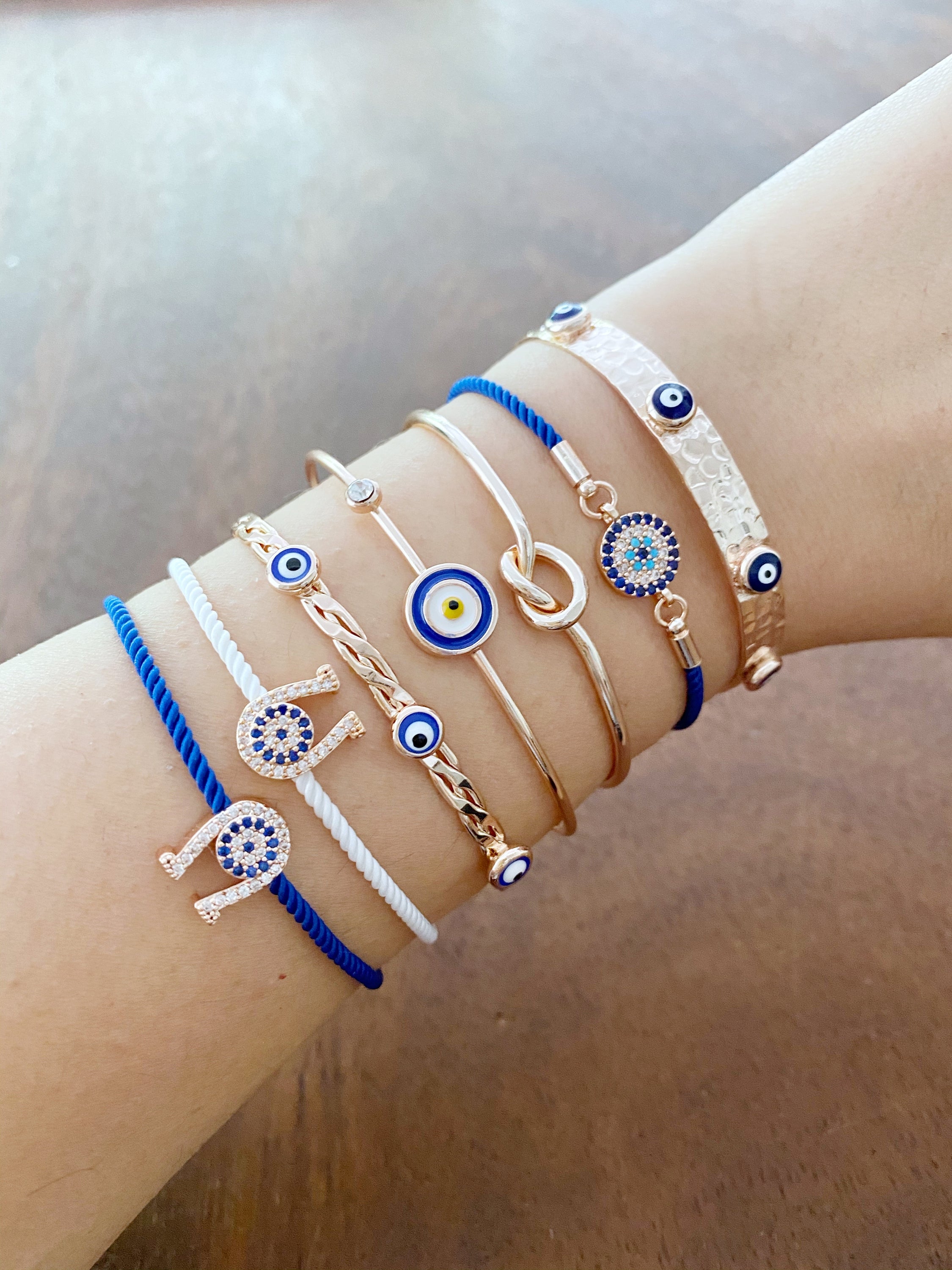 A beautiful Rose Gold Evil Eye Bracelet Set featuring various styles including bangles and cuffs, showcasing intricate designs and a protective evil eye symbol.