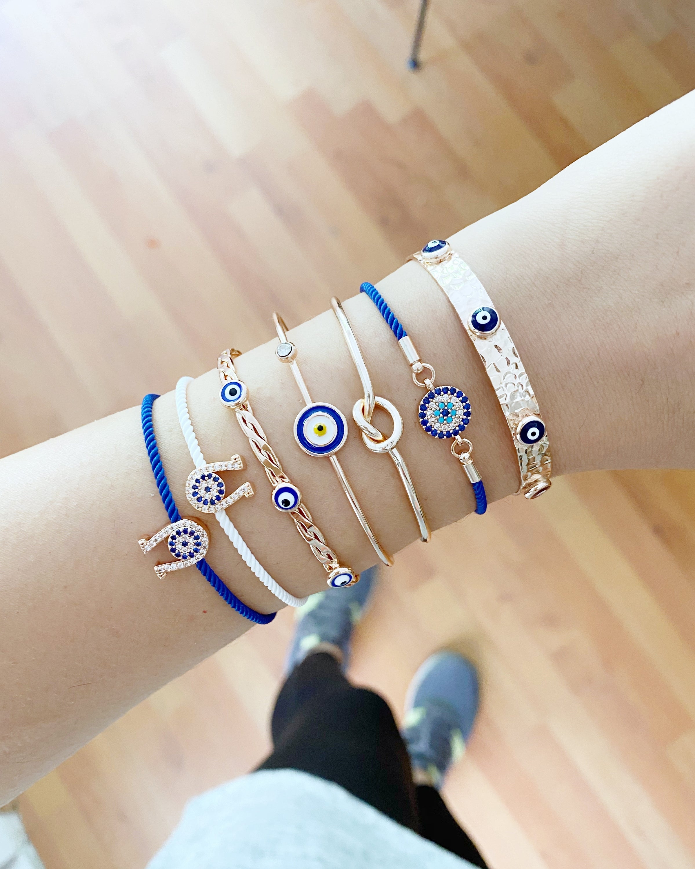 A beautiful Rose Gold Evil Eye Bracelet Set featuring various styles including bangles and cuffs, showcasing intricate designs and a protective evil eye symbol.