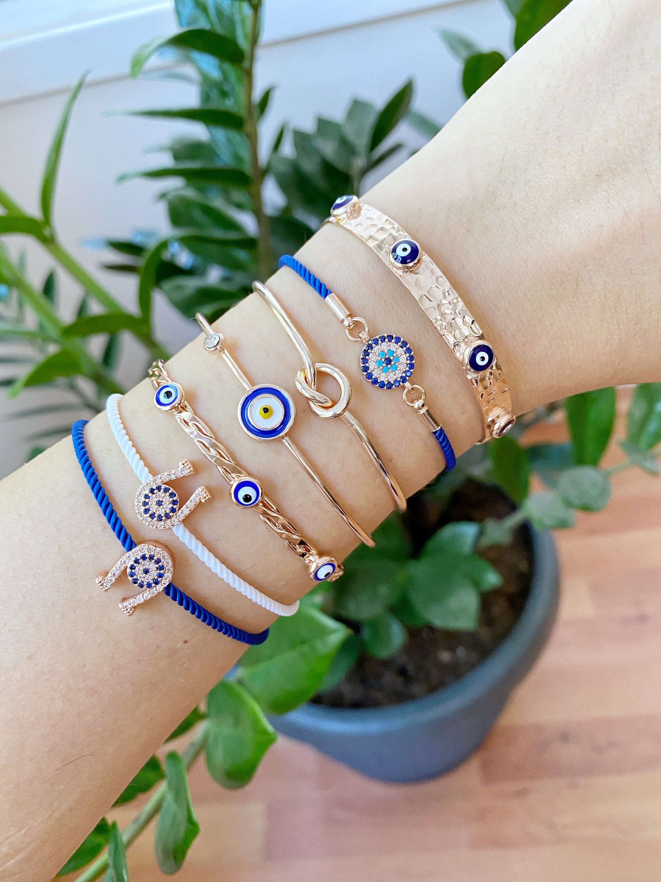 A beautiful Rose Gold Evil Eye Bracelet Set featuring various styles including bangles and cuffs, showcasing intricate designs and a protective evil eye symbol.