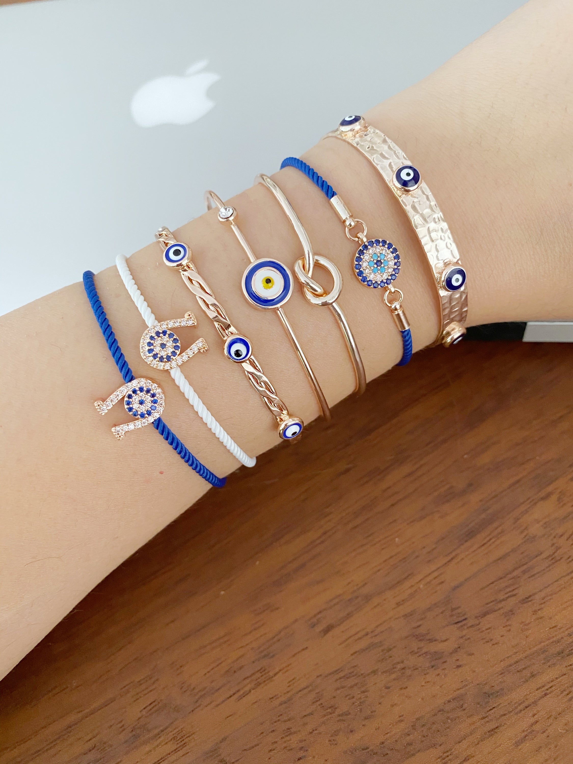 A beautiful Rose Gold Evil Eye Bracelet Set featuring various styles including bangles and cuffs, showcasing intricate designs and a protective evil eye symbol.