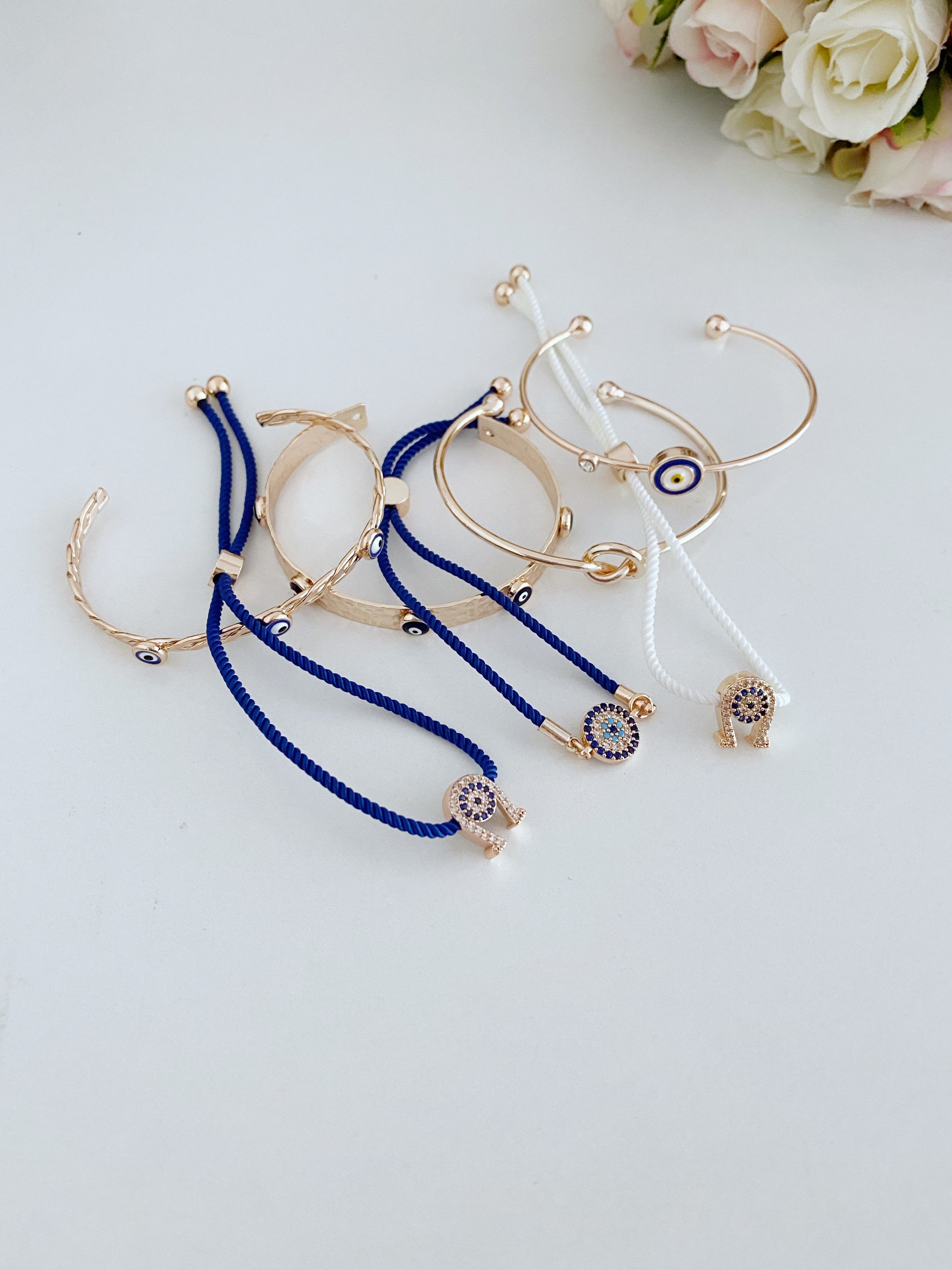 A beautiful Rose Gold Evil Eye Bracelet Set featuring various styles including bangles and cuffs, showcasing intricate designs and a protective evil eye symbol.