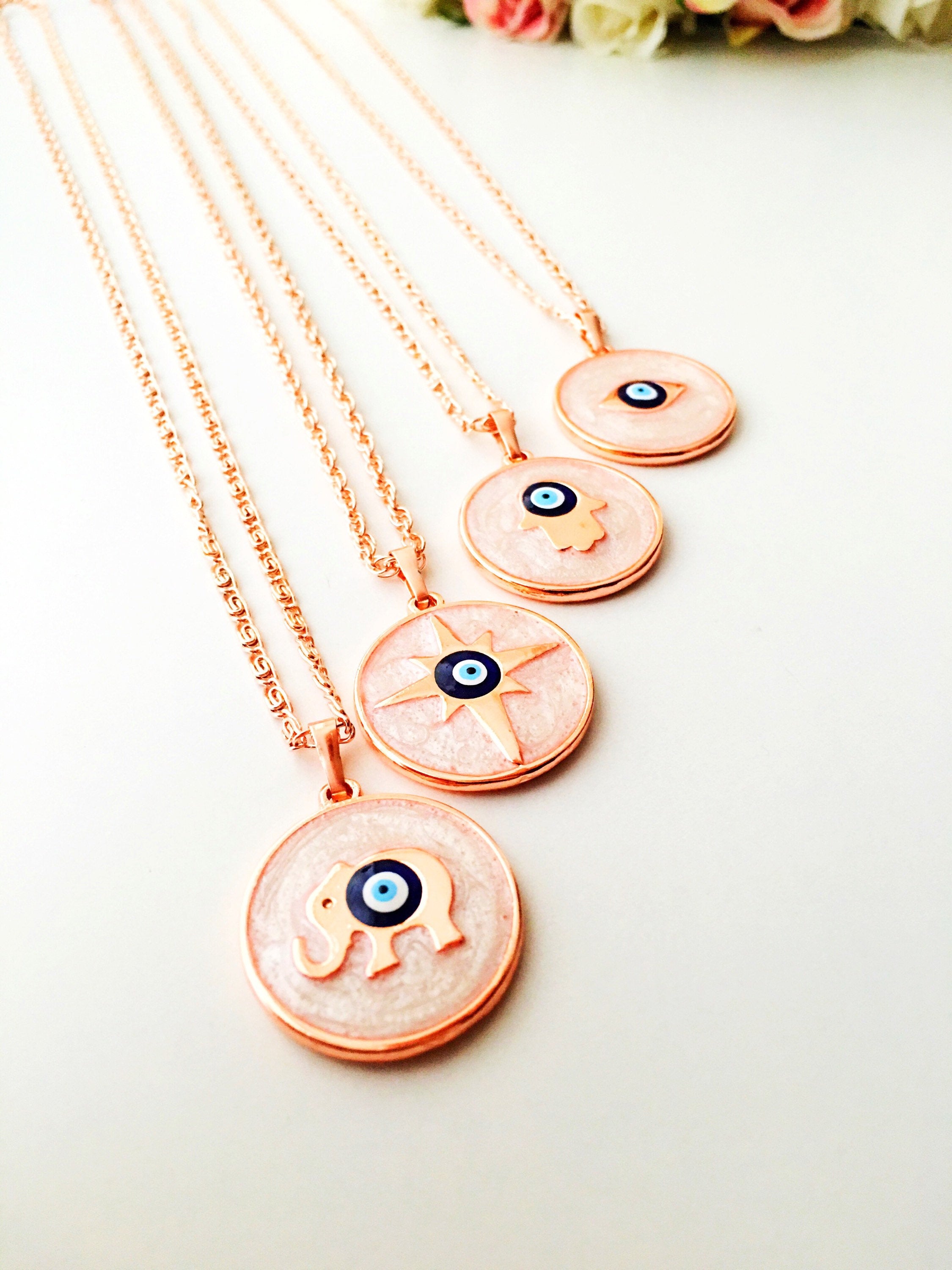 Rose Gold Evil Eye Necklace featuring Mother of Pearl, showcasing intricate design and charm options.