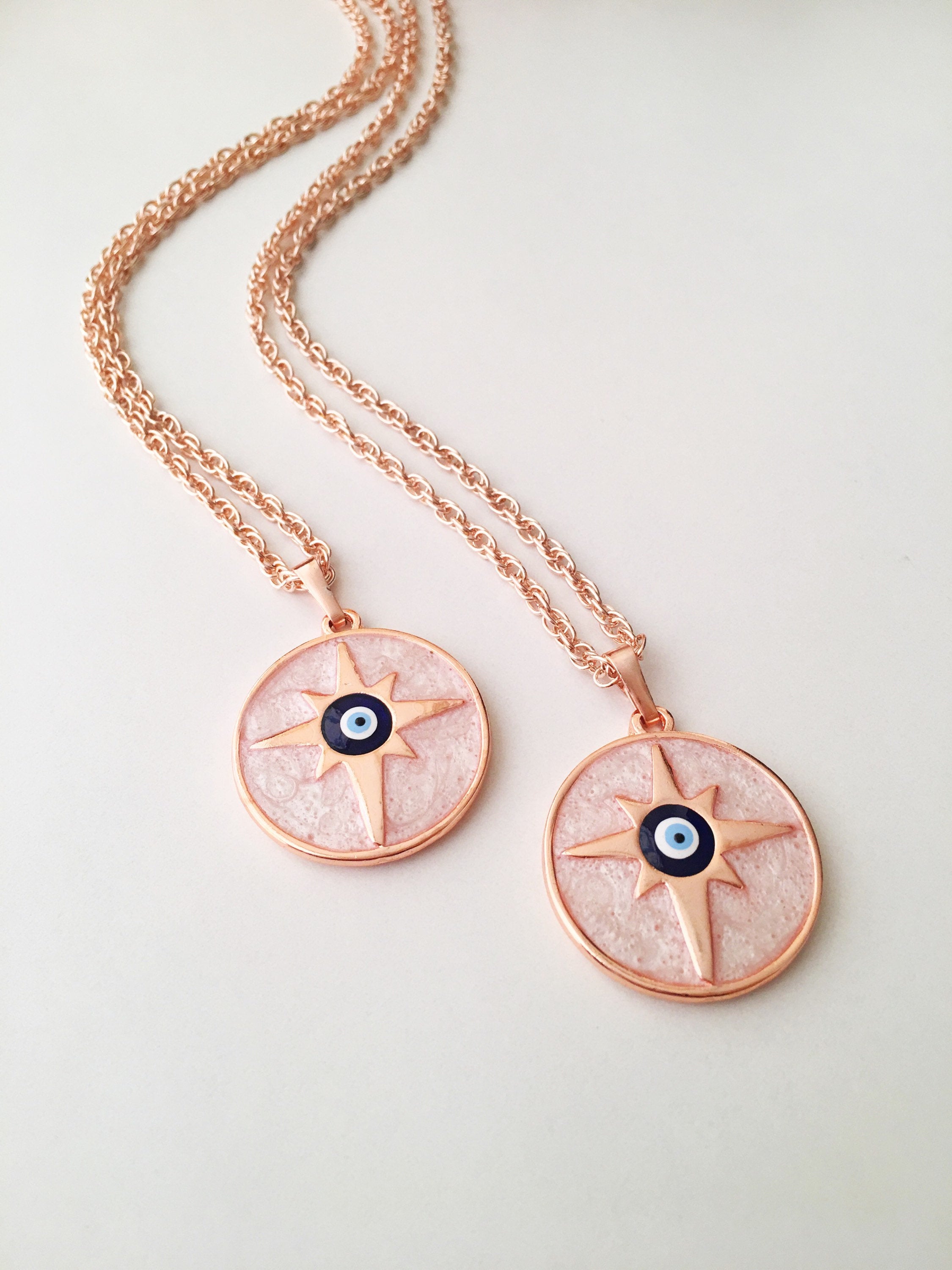 Rose Gold Evil Eye Necklace featuring Mother of Pearl, showcasing intricate design and charm options.