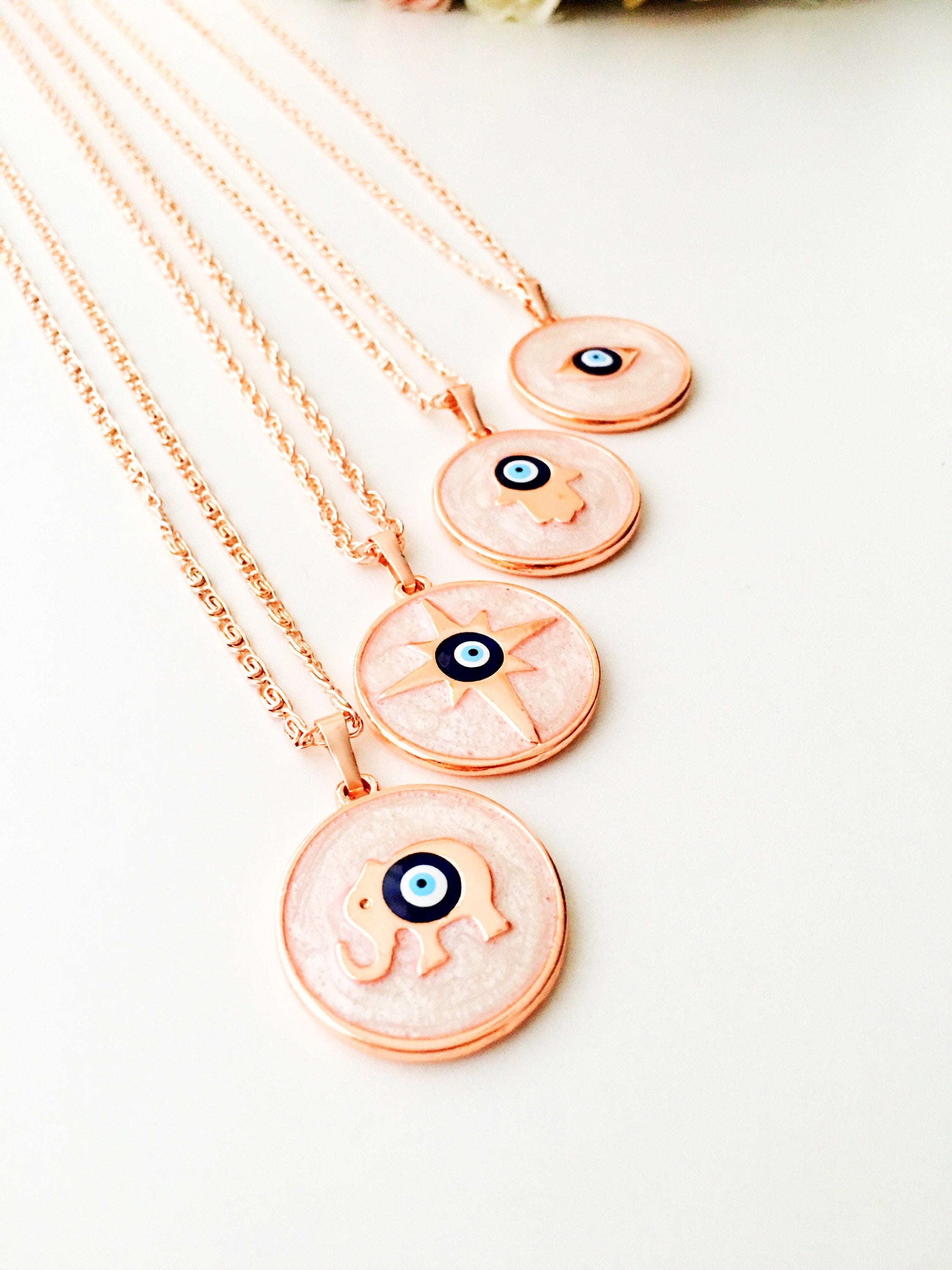 Rose Gold Evil Eye Necklace featuring Mother of Pearl, showcasing intricate design and charm options.