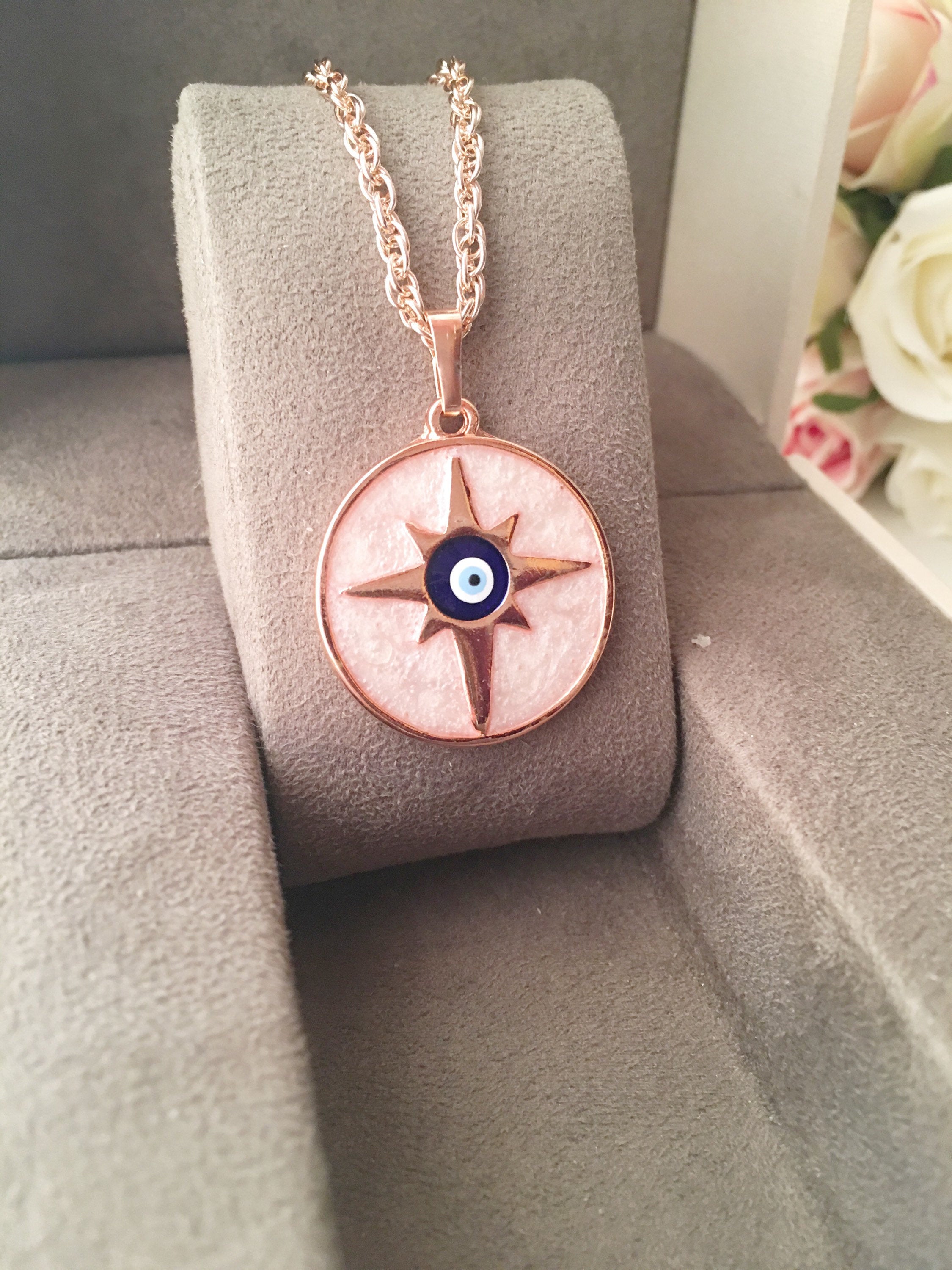 Rose Gold Evil Eye Necklace featuring Mother of Pearl, showcasing intricate design and charm options.