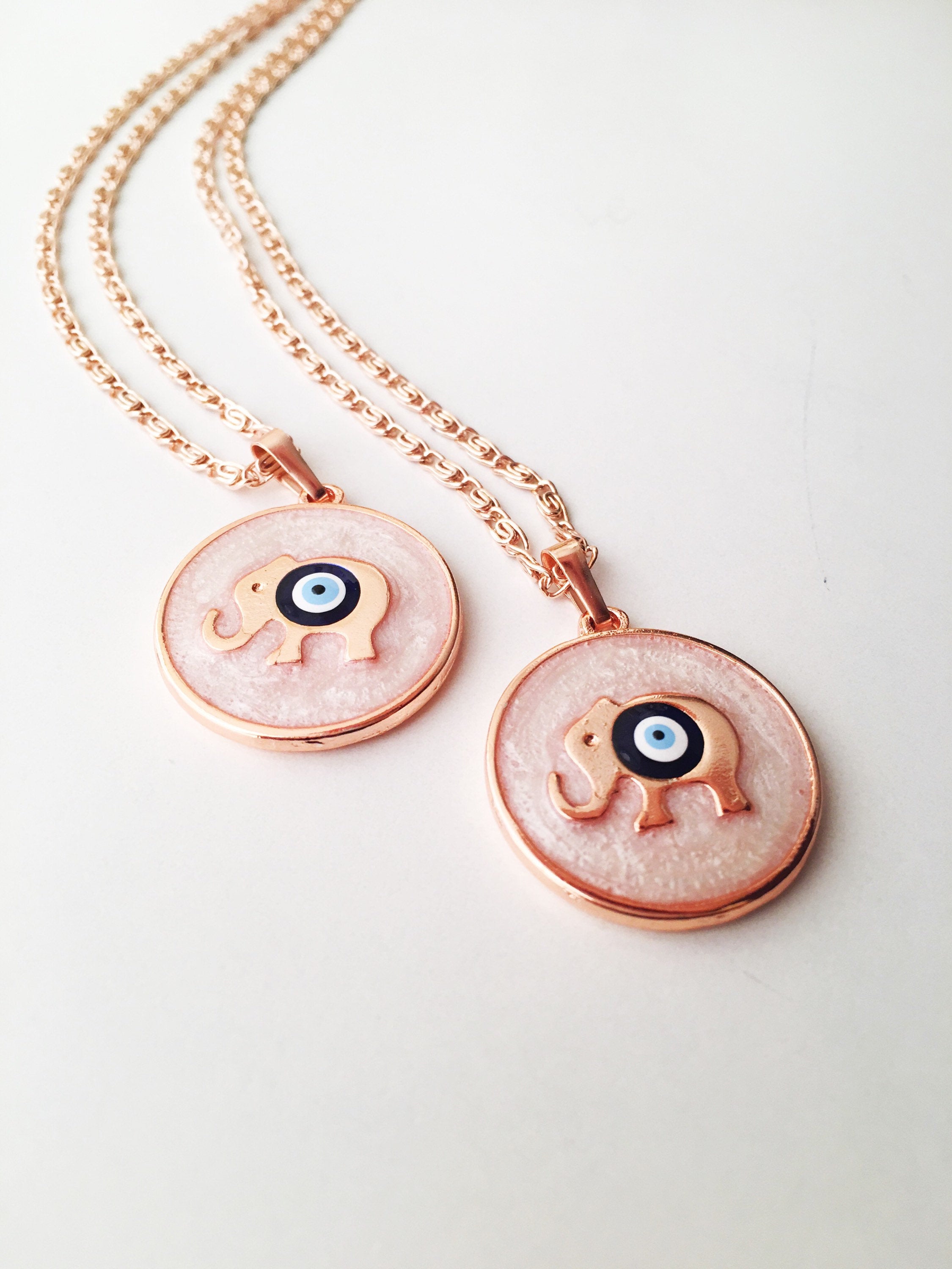 Rose Gold Evil Eye Necklace featuring Mother of Pearl, showcasing intricate design and charm options.