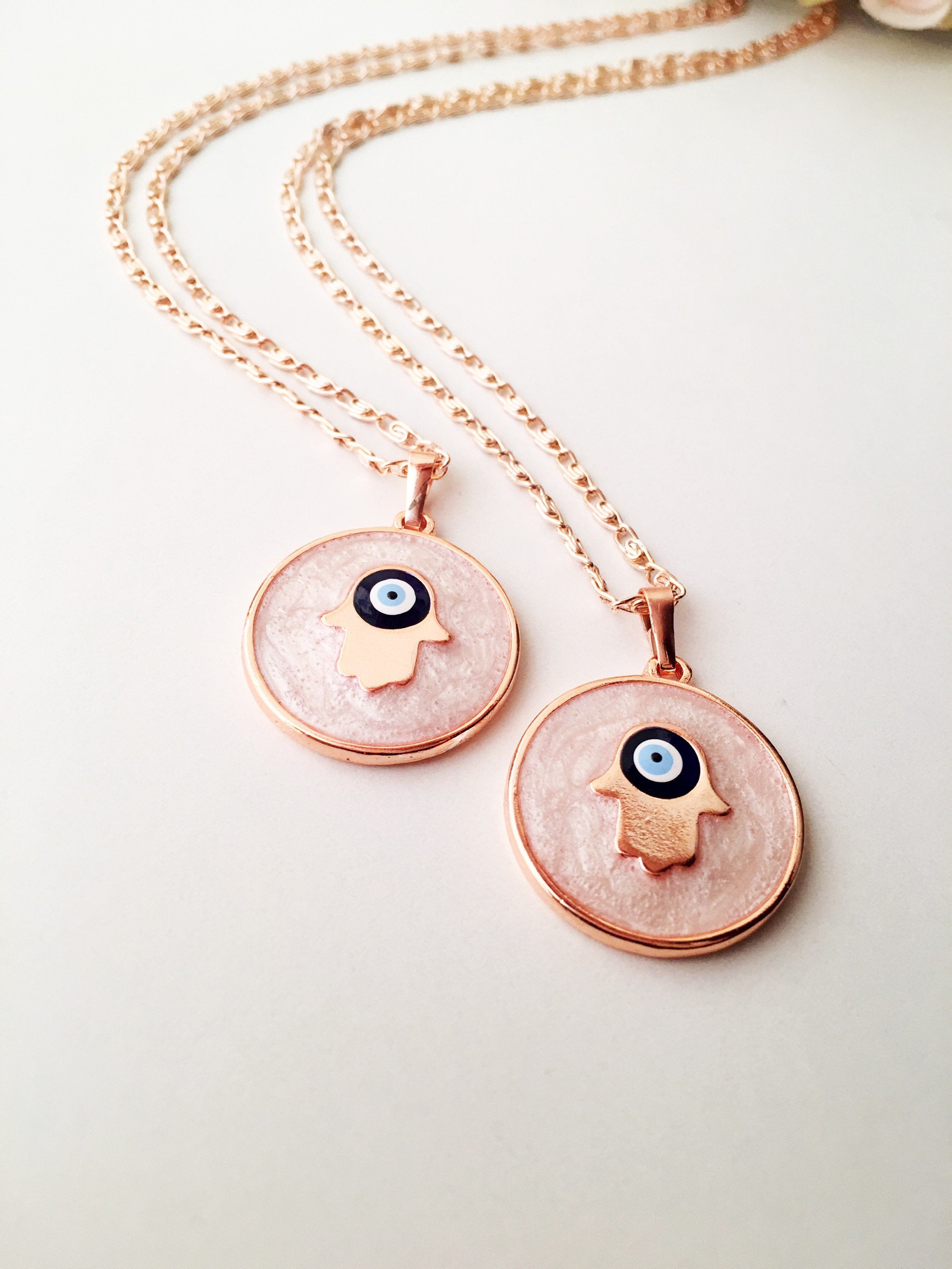 Rose Gold Evil Eye Necklace featuring Mother of Pearl, showcasing intricate design and charm options.