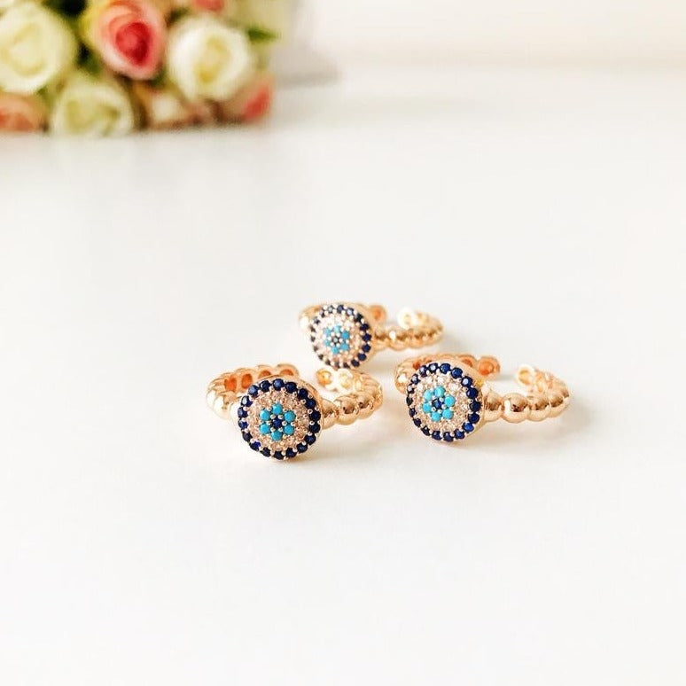A beautiful rose gold evil eye ring featuring a blue evil eye and sparkling cubic zirconia accents, adjustable for a perfect fit.