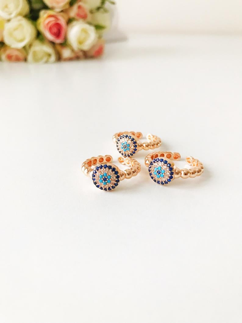 A beautiful rose gold evil eye ring featuring a blue evil eye and sparkling cubic zirconia accents, adjustable for a perfect fit.
