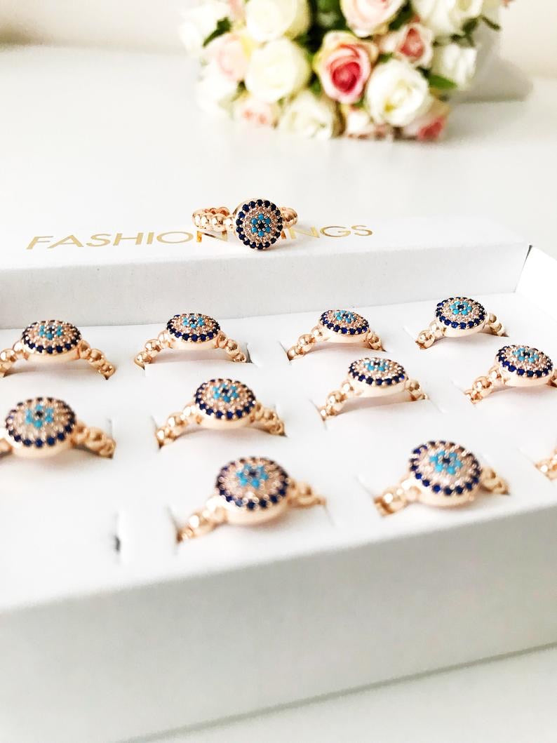 A beautiful rose gold evil eye ring featuring a blue evil eye and sparkling cubic zirconia accents, adjustable for a perfect fit.