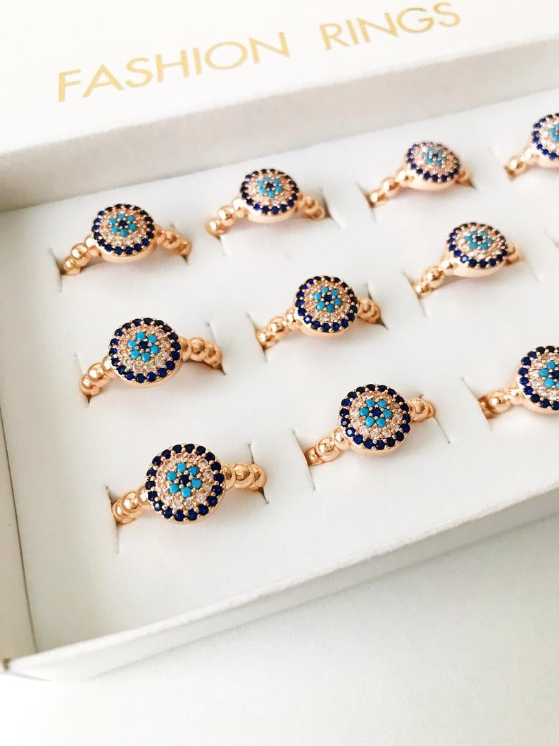 A beautiful rose gold evil eye ring featuring a blue evil eye and sparkling cubic zirconia accents, adjustable for a perfect fit.