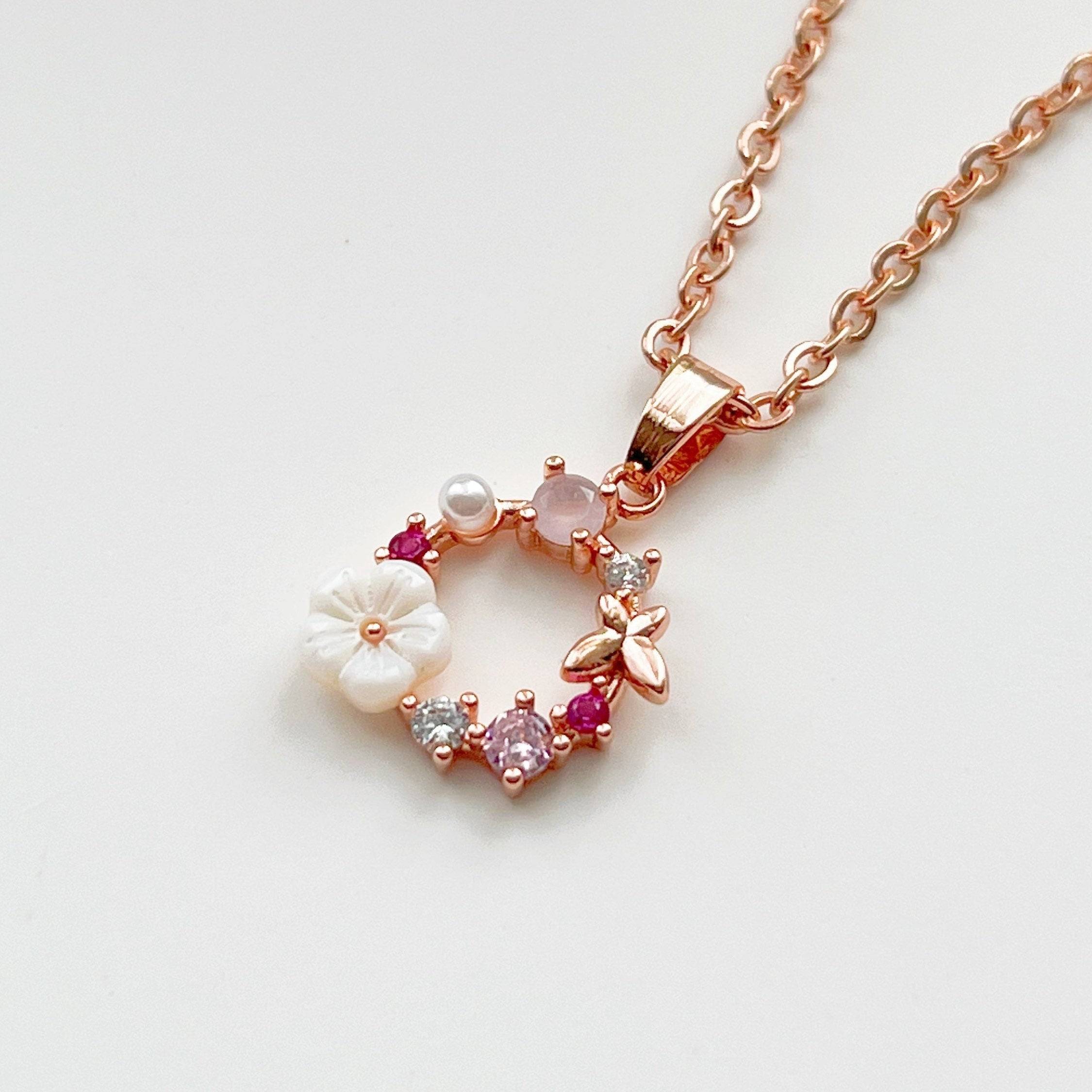 Elegant rose gold flower wreath necklace adorned with pink crystals and pearl, showcasing a delicate handmade design.