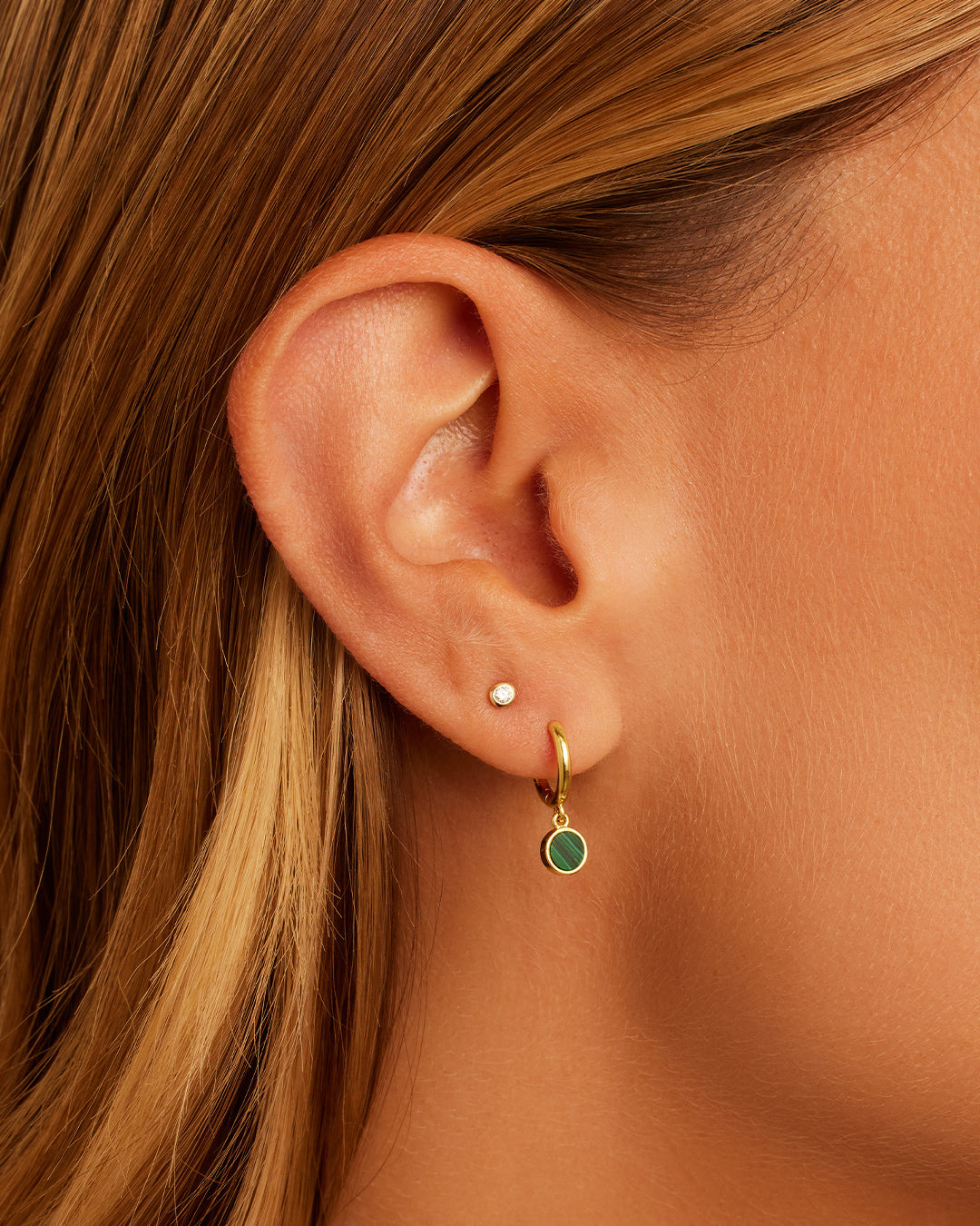 A pair of elegant Rose Marble Coin Huggies earrings featuring unique rose marble coins and a secure huggie closure.