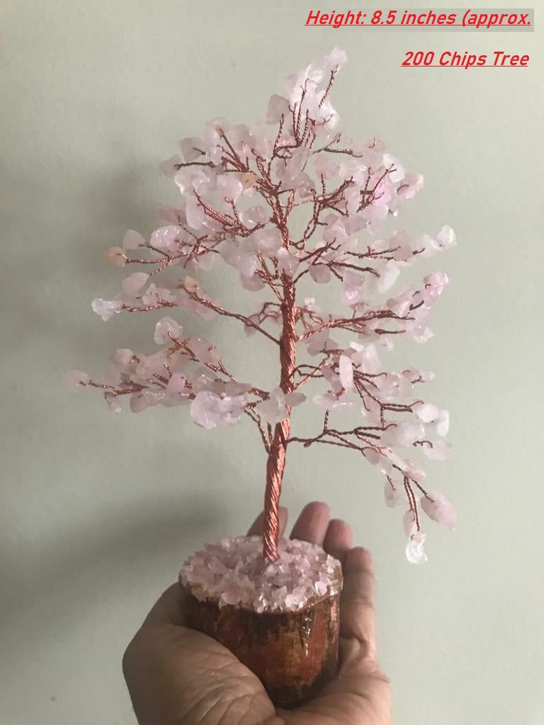 A beautiful Rose Quartz Gemstone Tree with 200 chips, featuring a wooden base and delicate pink crystals, symbolizing love and healing.