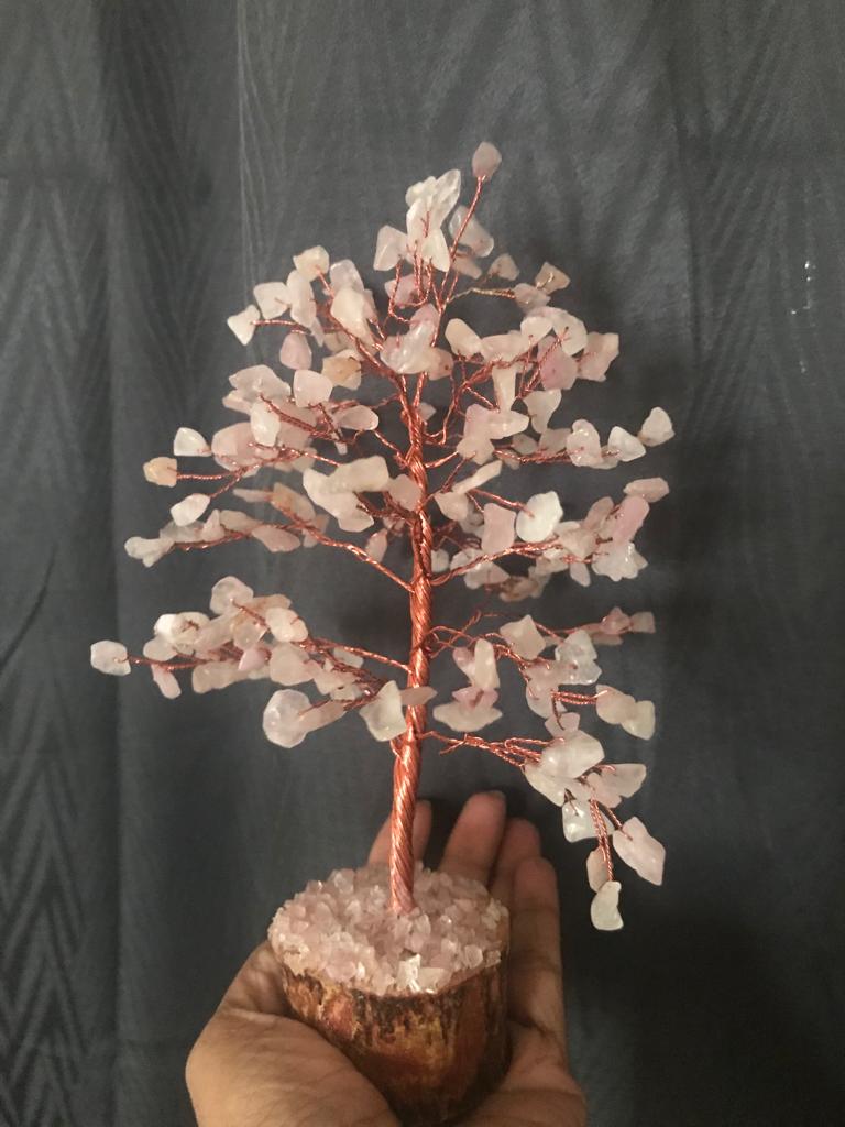 A beautiful Rose Quartz Gemstone Tree with 200 chips, featuring a wooden base and delicate pink crystals, symbolizing love and healing.