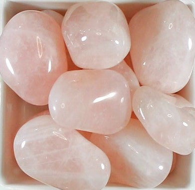 A collection of smooth, pink Rose Quartz gemstone tumble stones, showcasing their natural beauty and unique shapes.