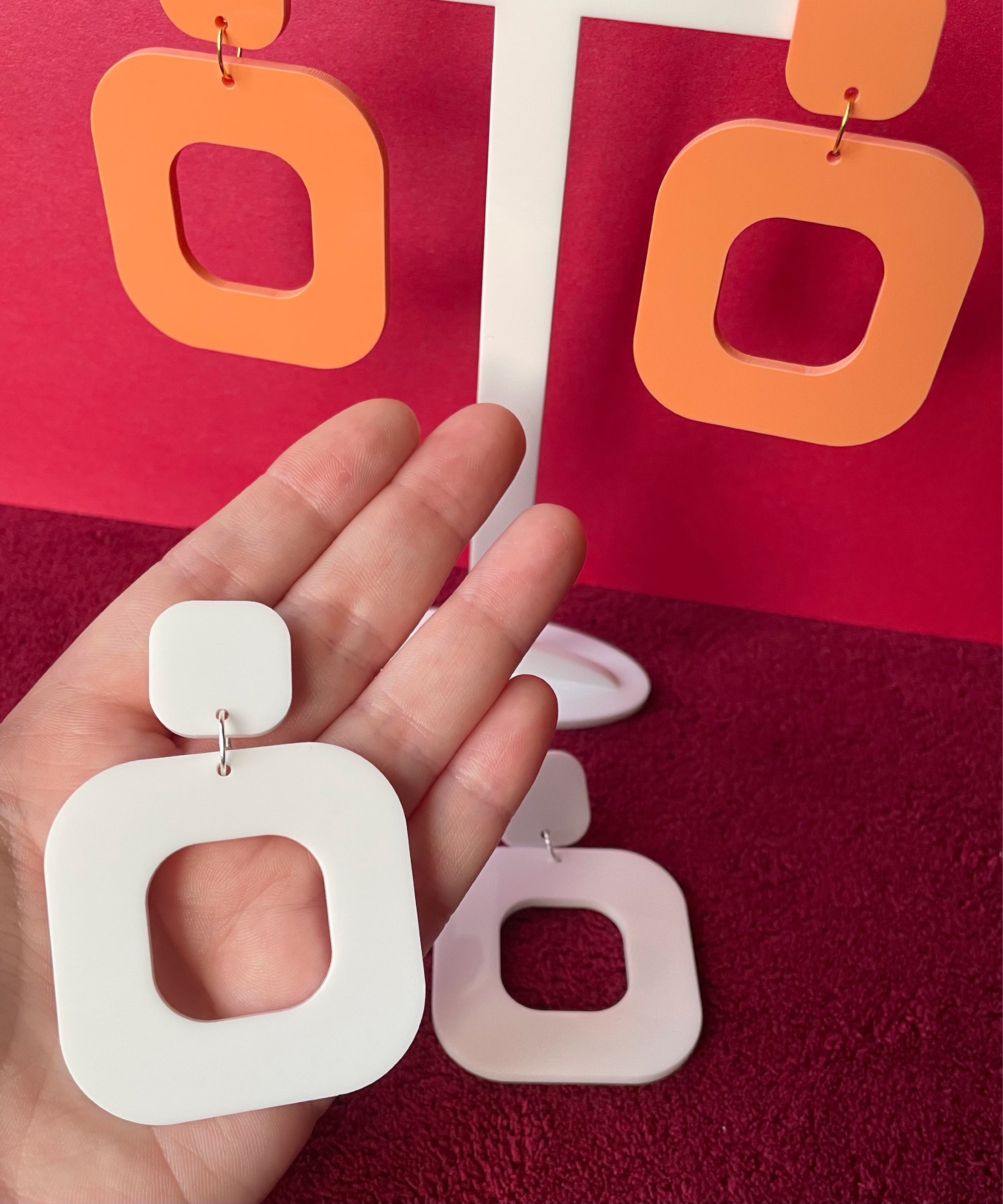 A pair of stylish rounded square earrings made from laser cut acrylic, showcasing vibrant colors and a modern design.