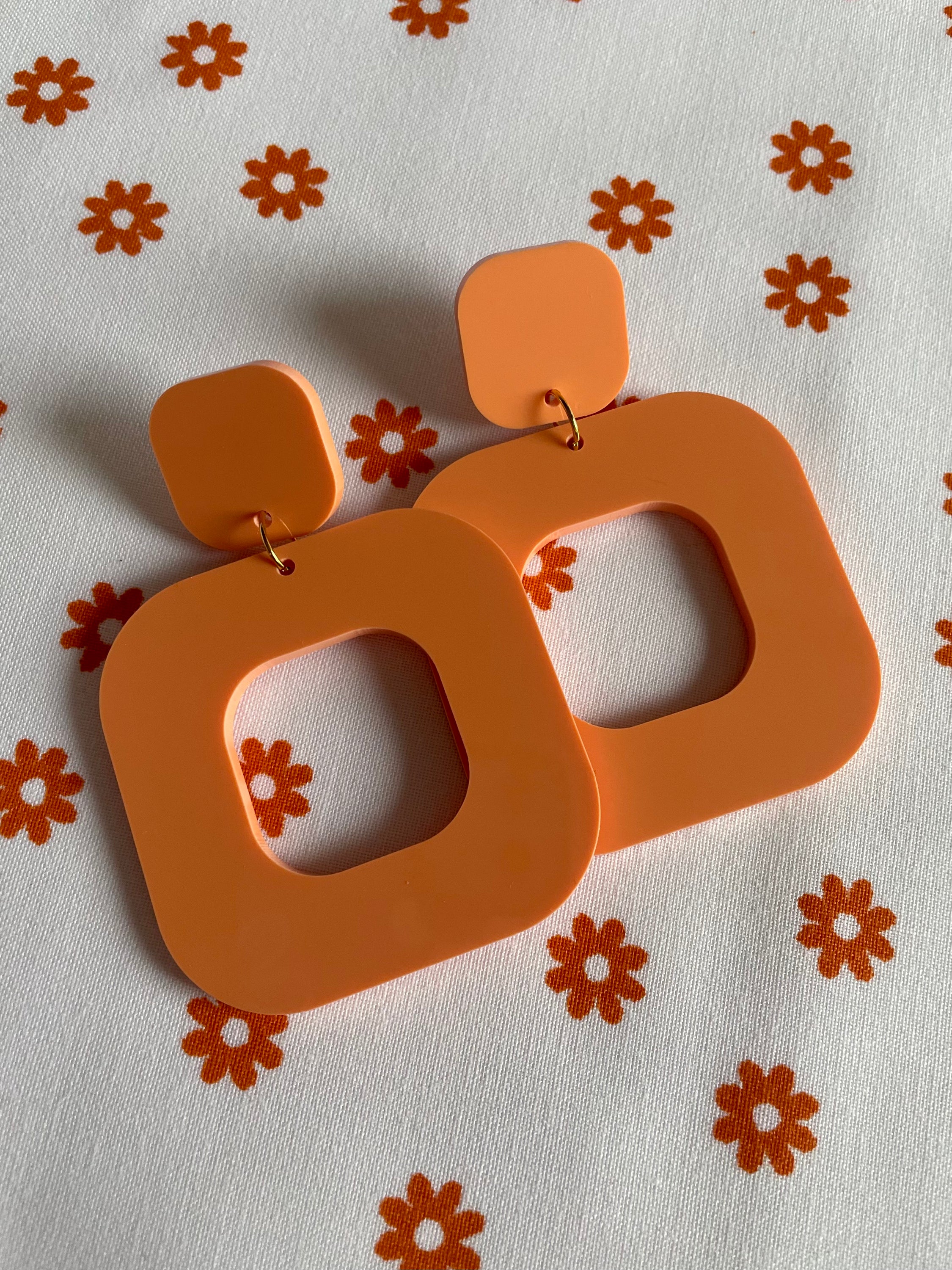 A pair of stylish rounded square earrings made from laser cut acrylic, showcasing vibrant colors and a modern design.