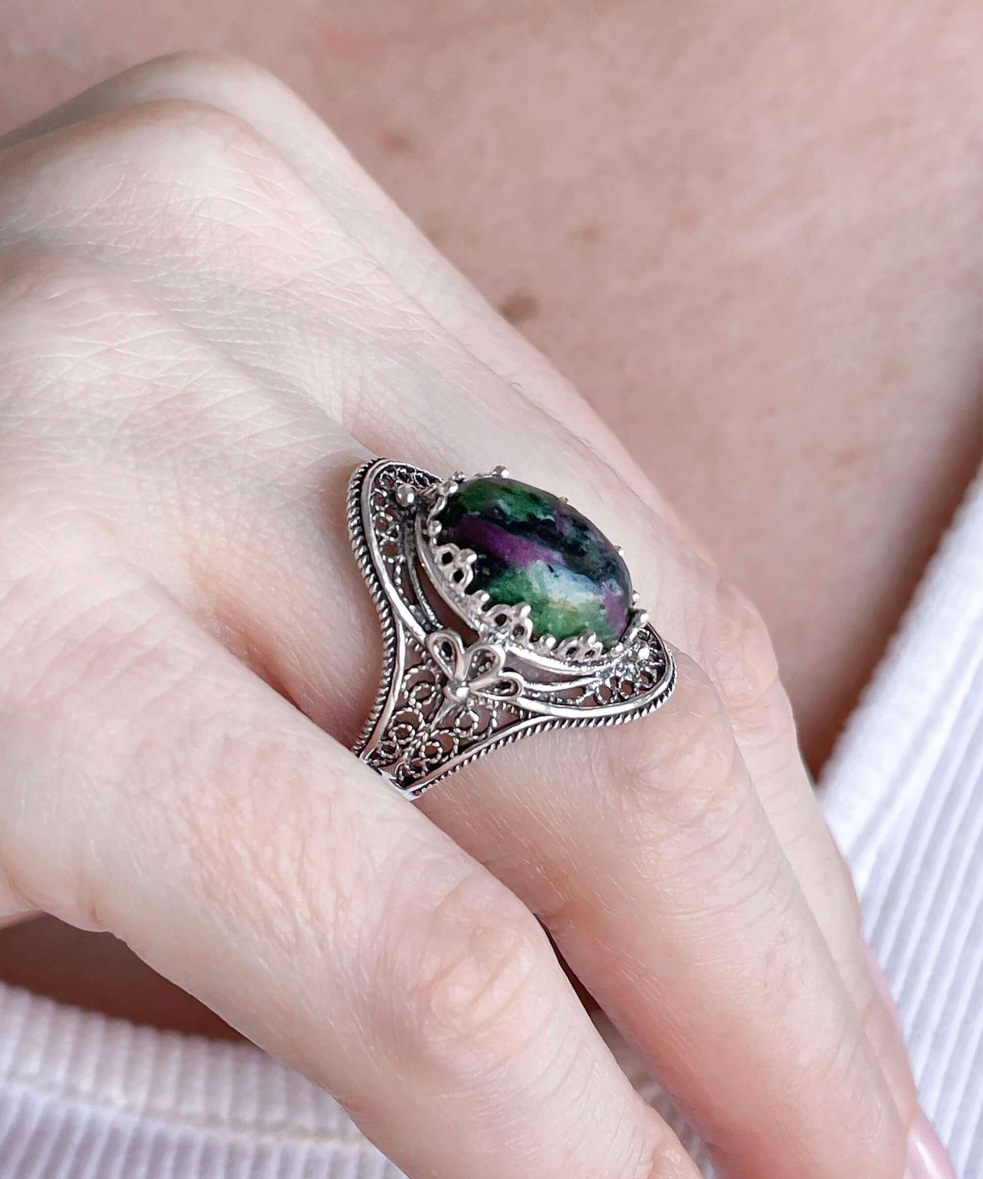 A stunning Ruby Zoisite gemstone filigree art ring made of sterling silver, showcasing intricate designs and a vibrant green-red stone.