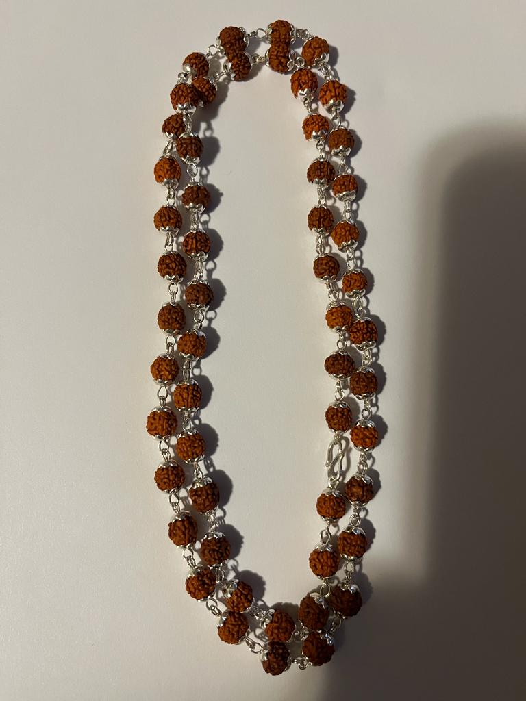 A stunning Rudraksha Mala featuring 54 natural beads with elegant silver caps, symbolizing spirituality and inner peace.