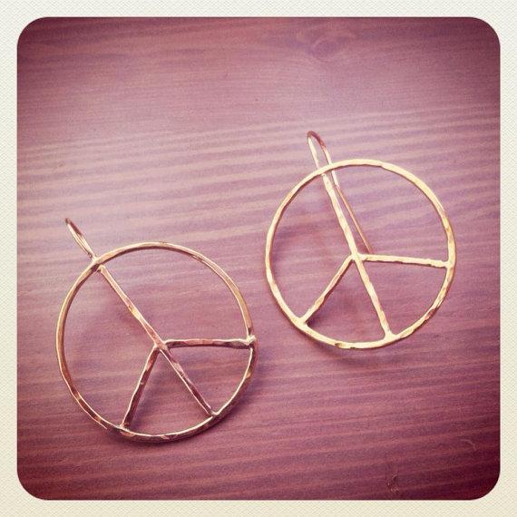 A pair of large rustic peace sign earrings made from hammered 16g wire, showcasing a unique handmade design with an organic texture.