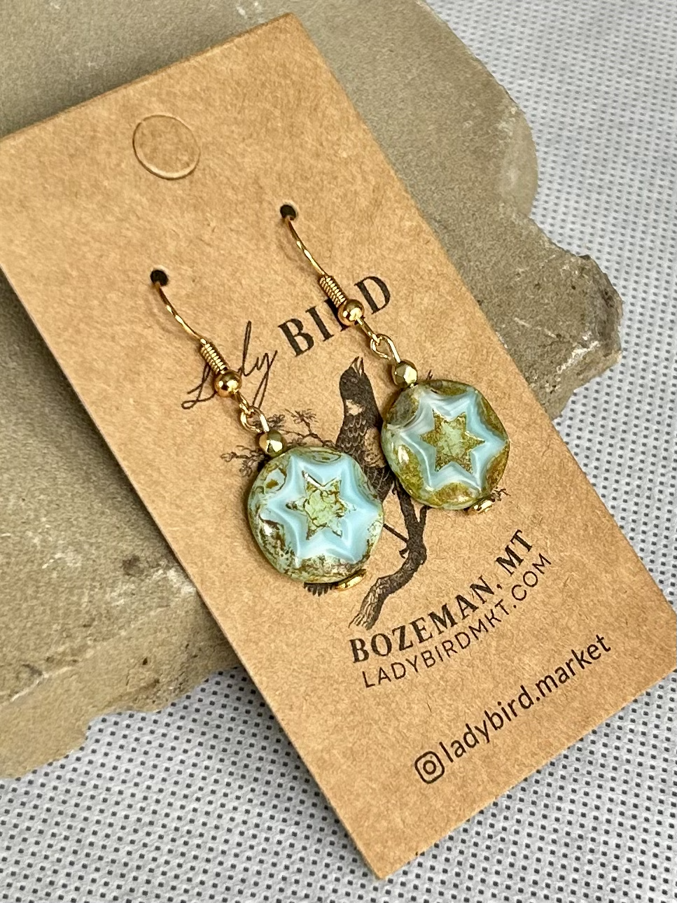 Rustic turquoise dangle earrings featuring etched star design, perfect for boho and vintage styles.
