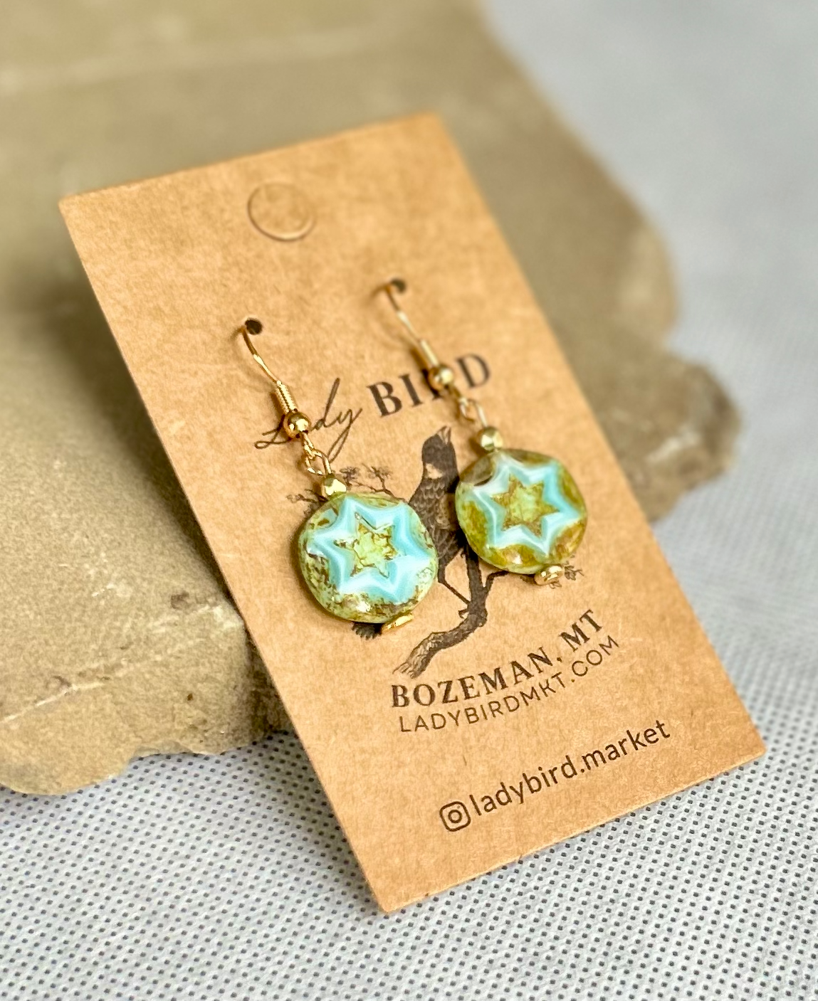 Rustic turquoise dangle earrings featuring etched star design, perfect for boho and vintage styles.