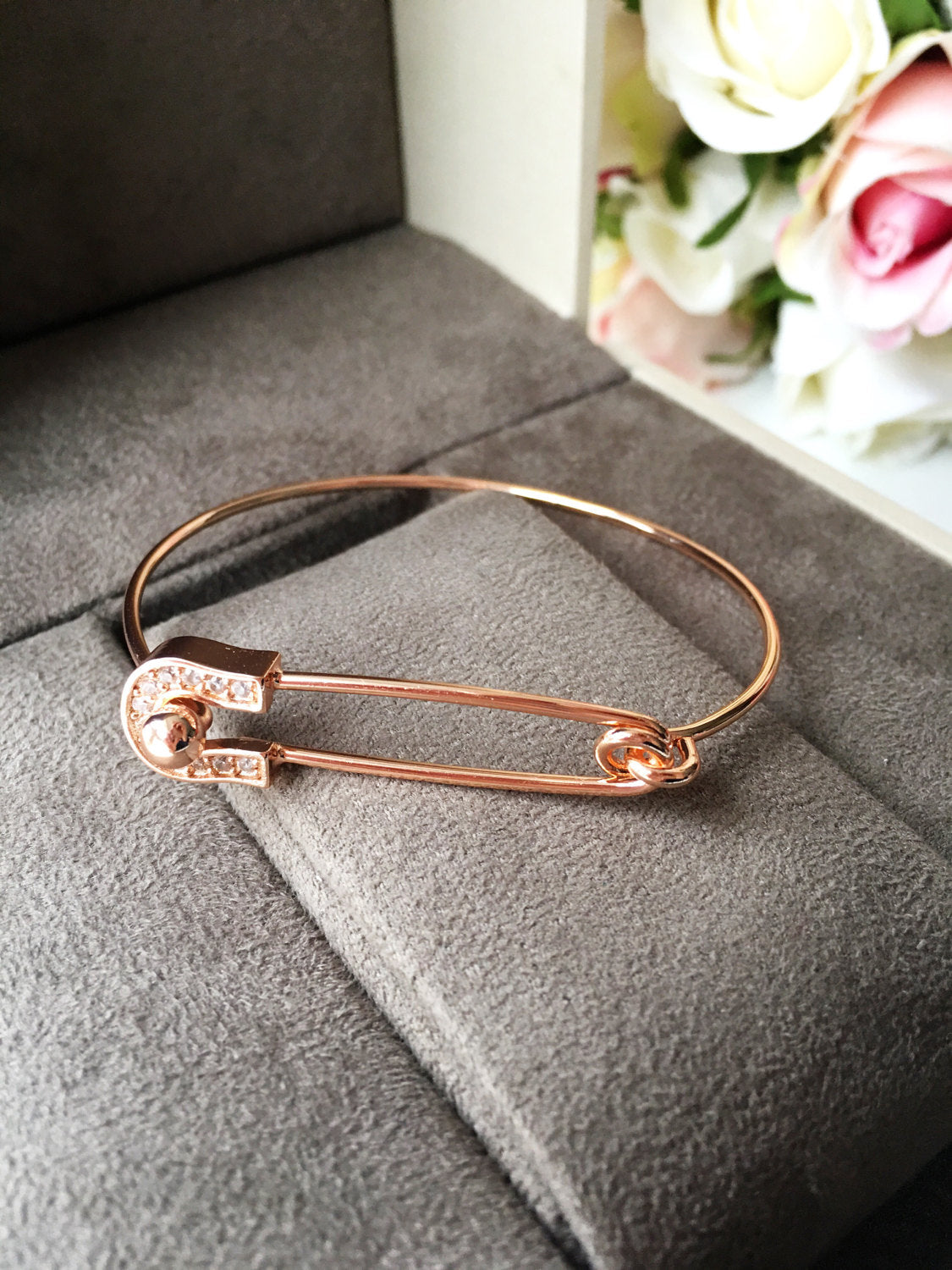 Stylish Safety Pin Bangle Bracelet in silver, gold, and rose gold with zirconia accents, showcasing a modern design.