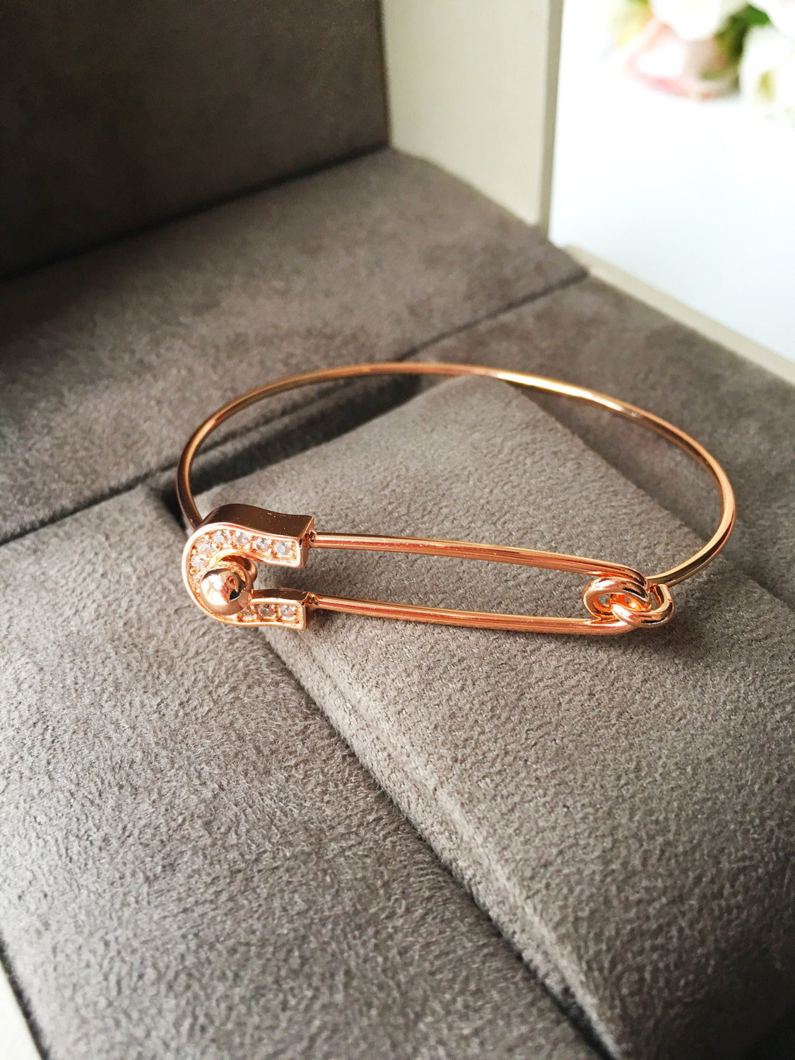 Stylish Safety Pin Bangle Bracelet in silver, gold, and rose gold with zirconia accents, showcasing a modern design.