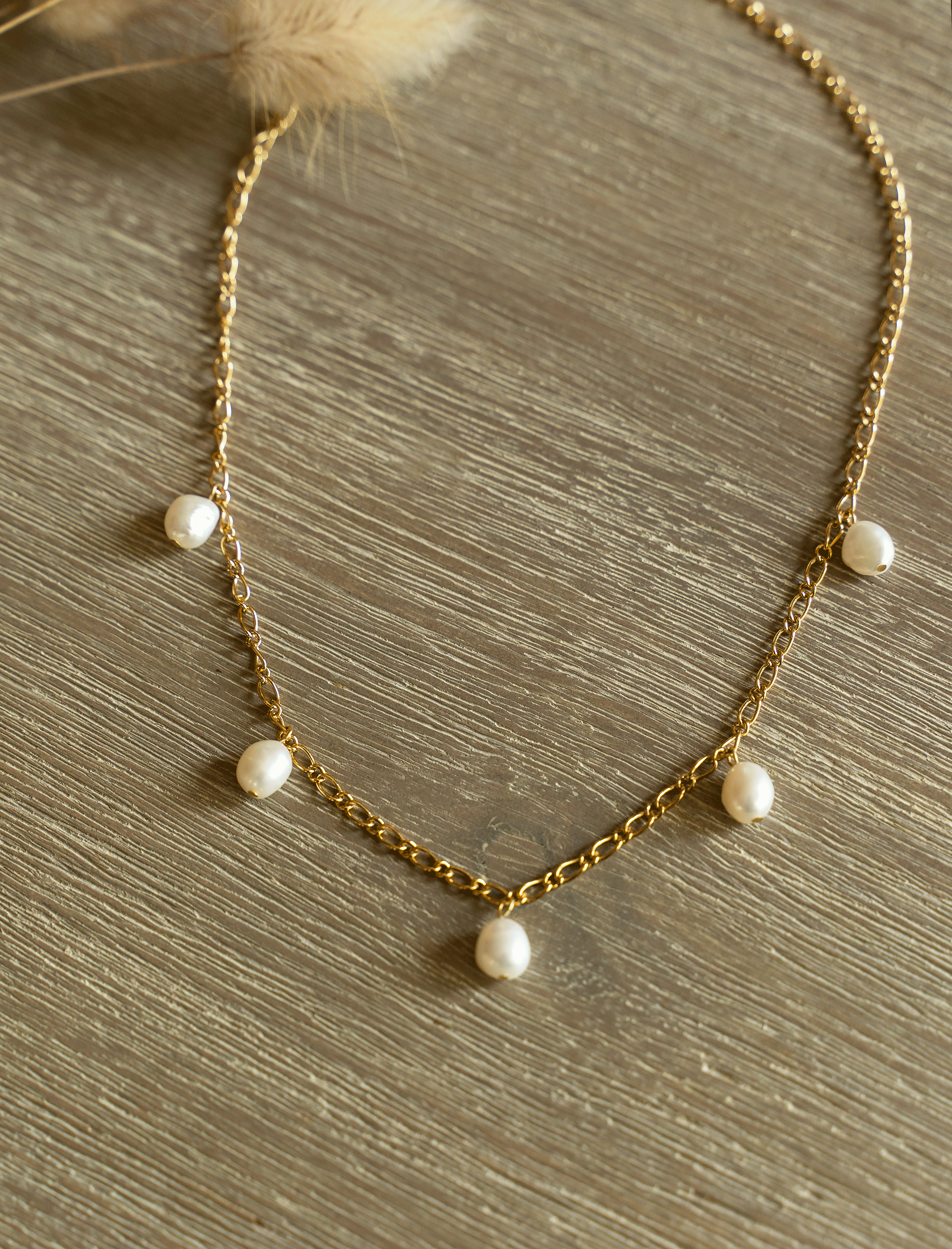 SAKURA Necklace featuring white freshwater pearls on an 18k gold plated Figaro link chain, showcasing elegance and style.