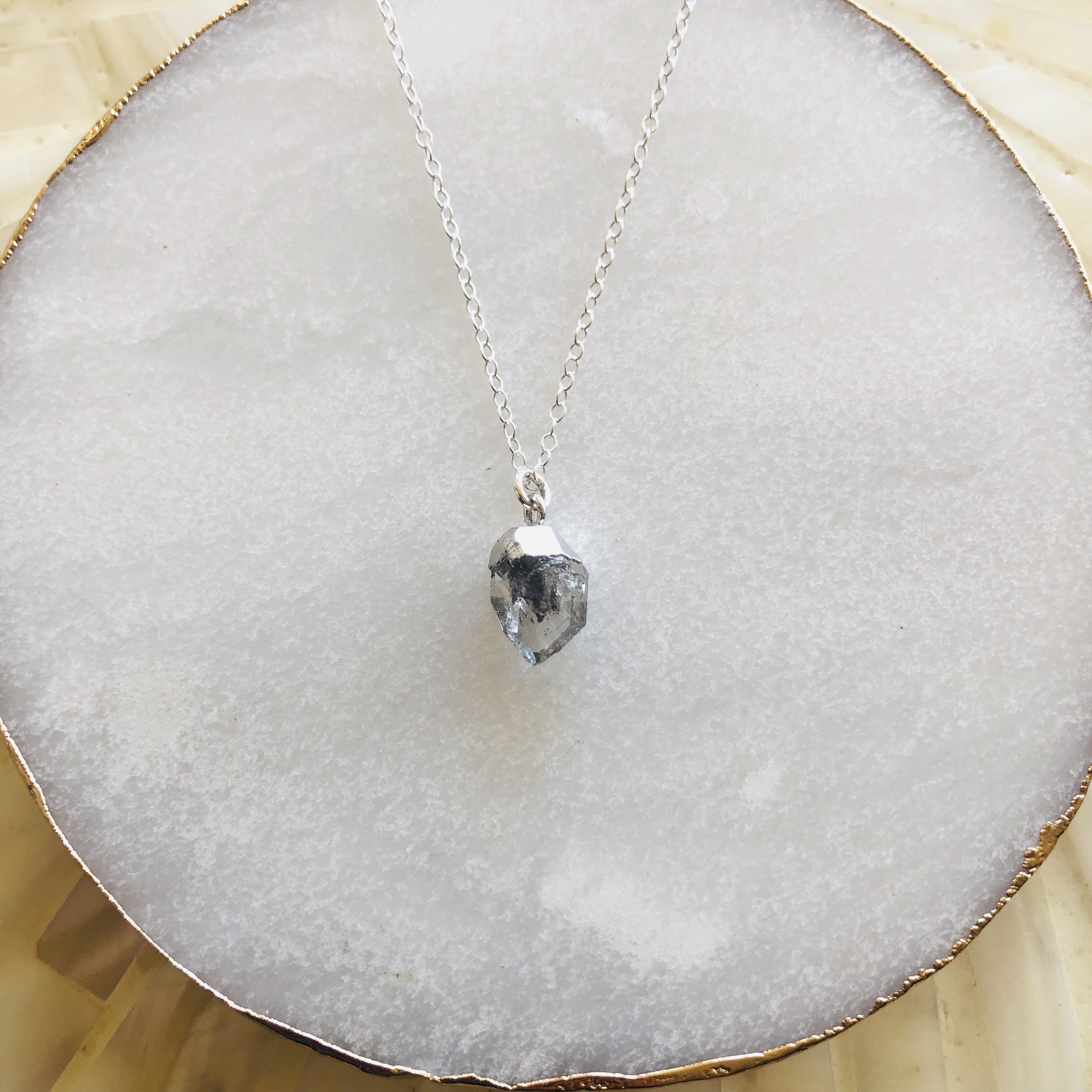A stunning silver necklace featuring unique salt and pepper Herkimer diamonds, elegantly displayed on a soft background.